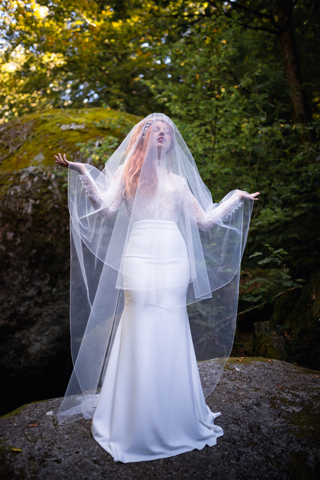 femme portant une robe de mariée sirène en dentelle avec un voile de mariée en bretagne.