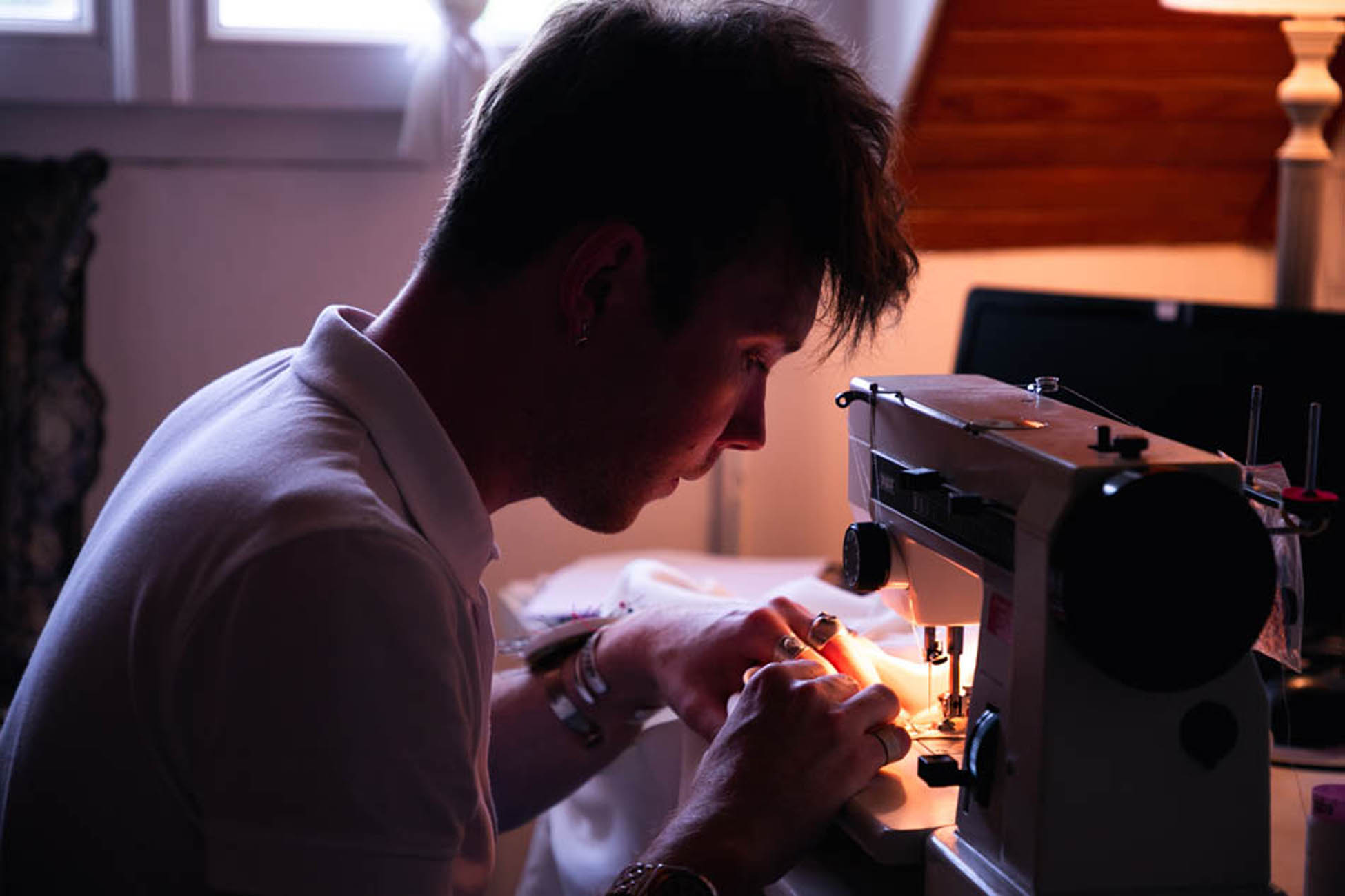 Thom De Corbie travaillant devant sa machine à coudre.