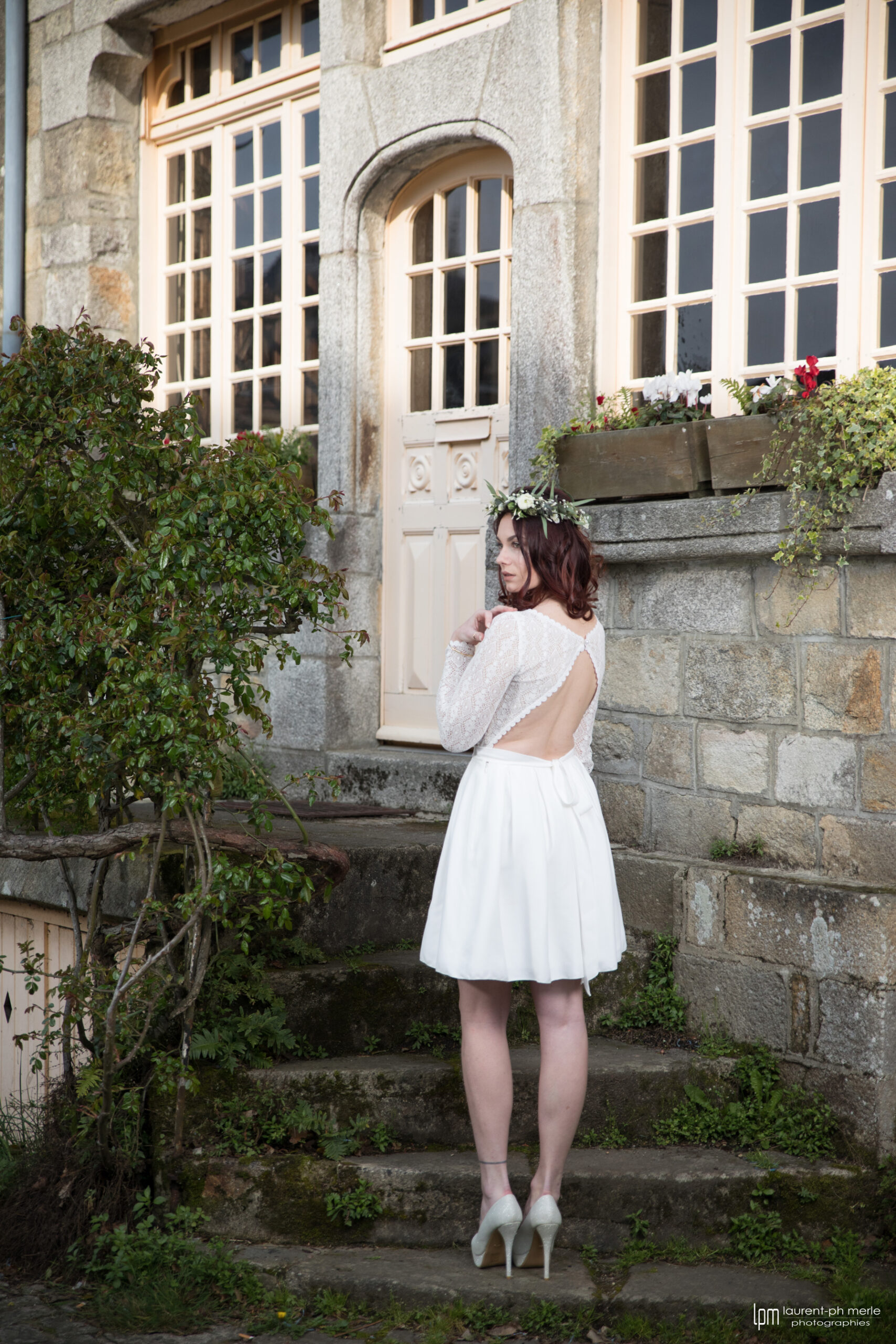 Femme portant une robe de mariée courte en dentelle en Bretagne.