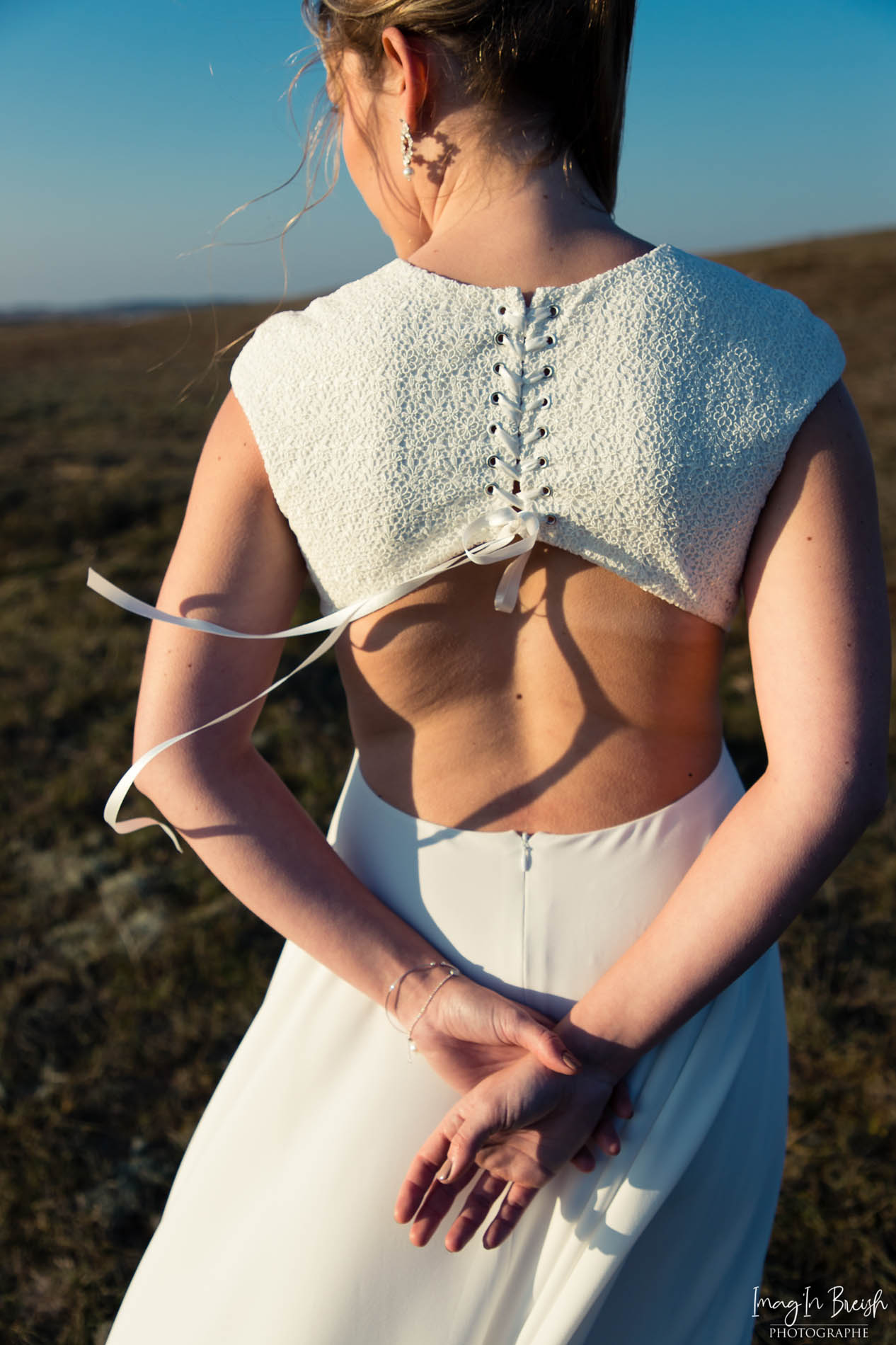 Femme portant une robe de mariée en dentelle en Bretagne.