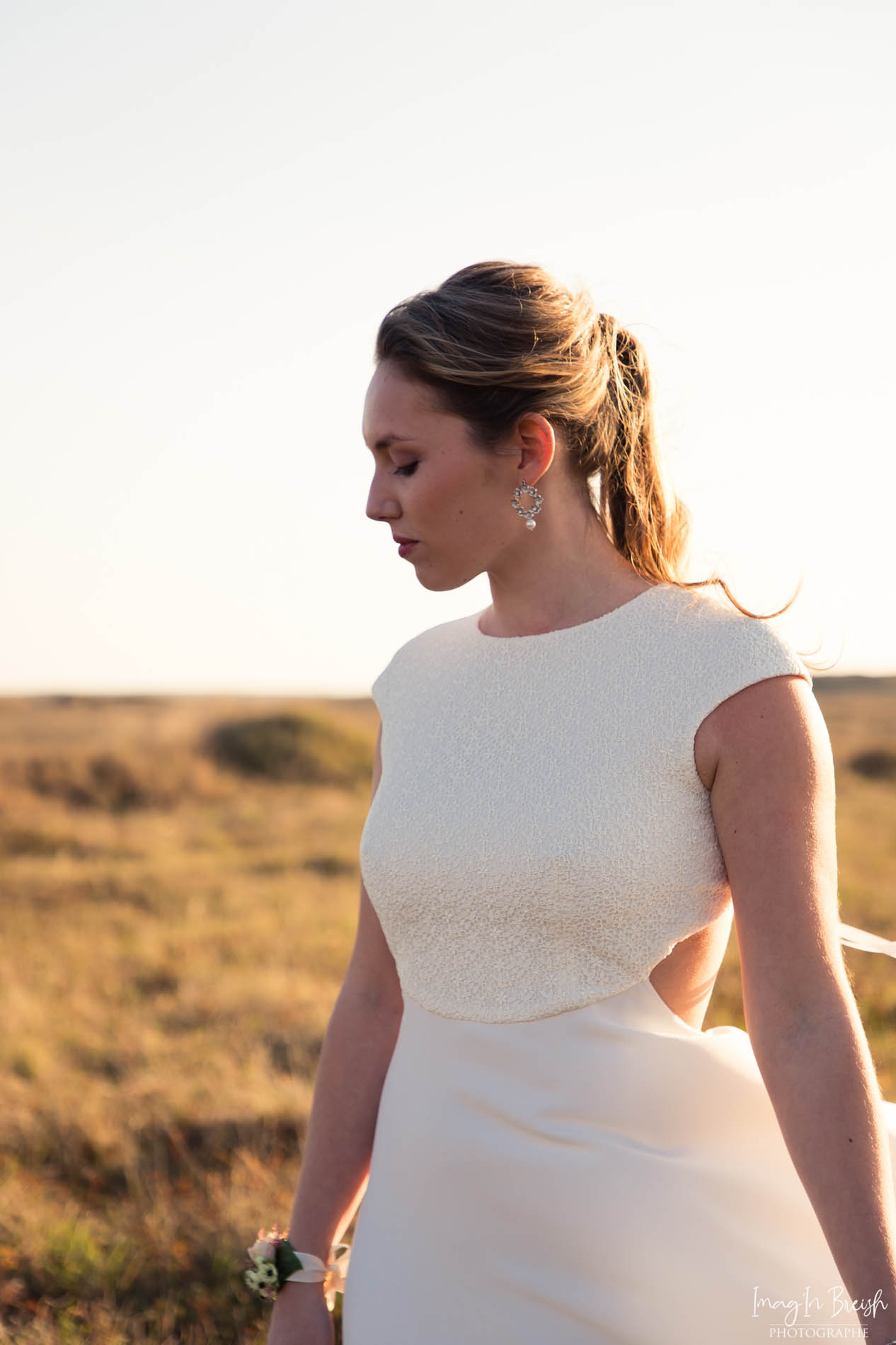 Femme portant une robe de mariée en dentelle en Bretagne.