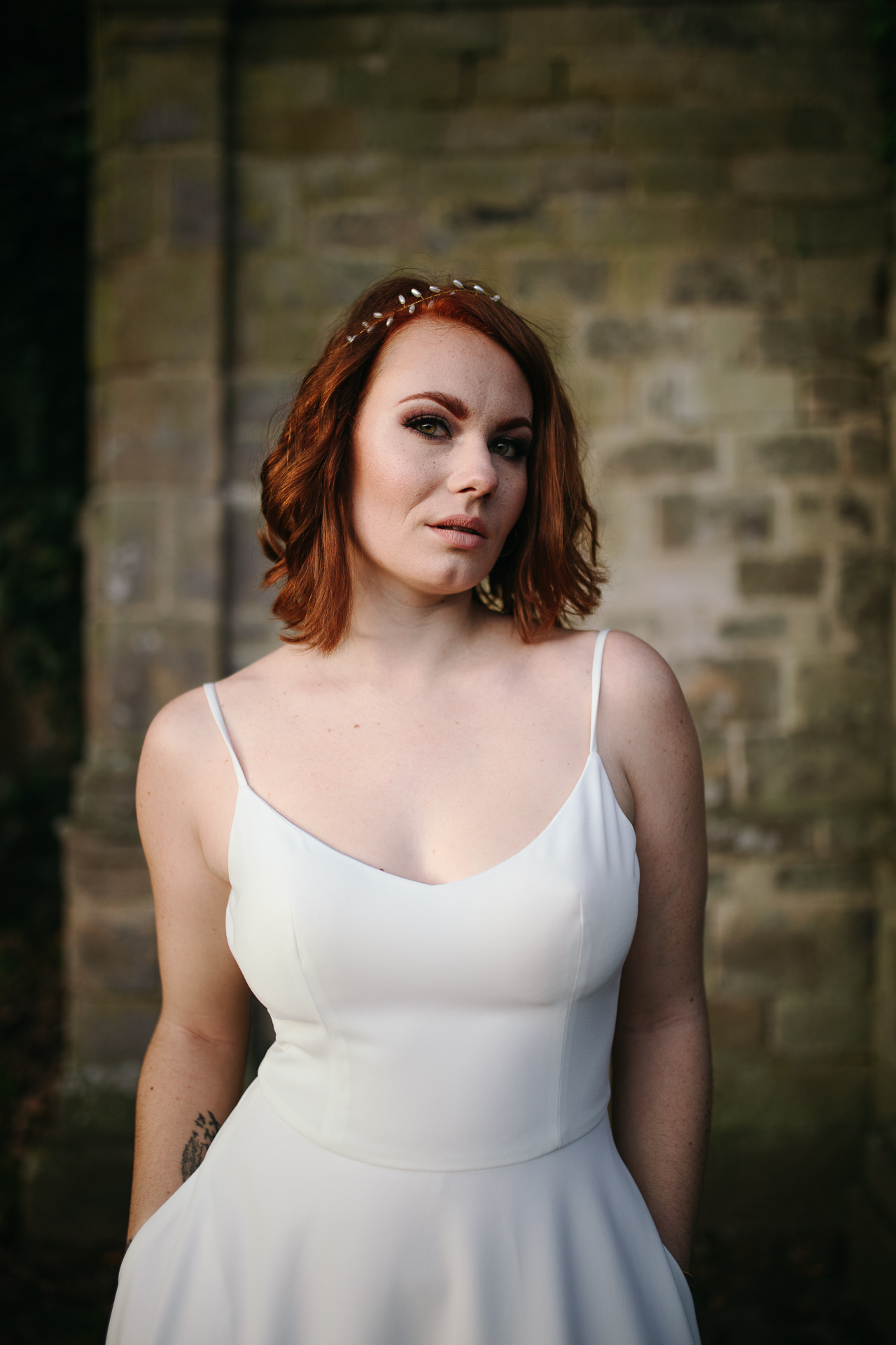 Femme portant une robe de mariée simple en Bretagne créée par Thom De Corbie.