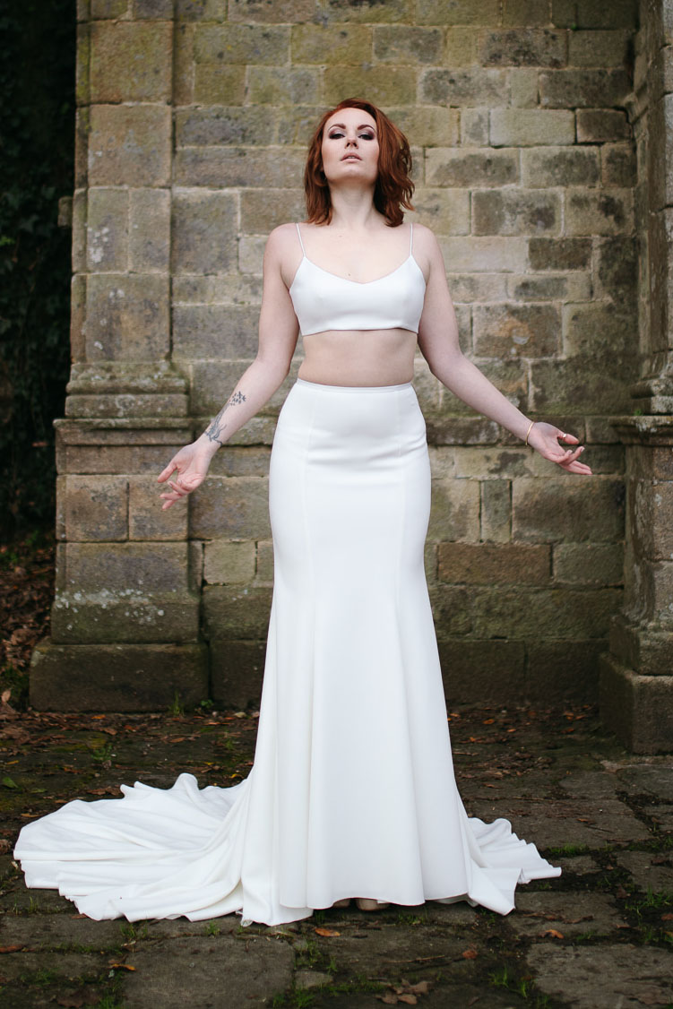 Femme portant une robe de mariée simple en Bretagne créée par Thom De Corbie.
