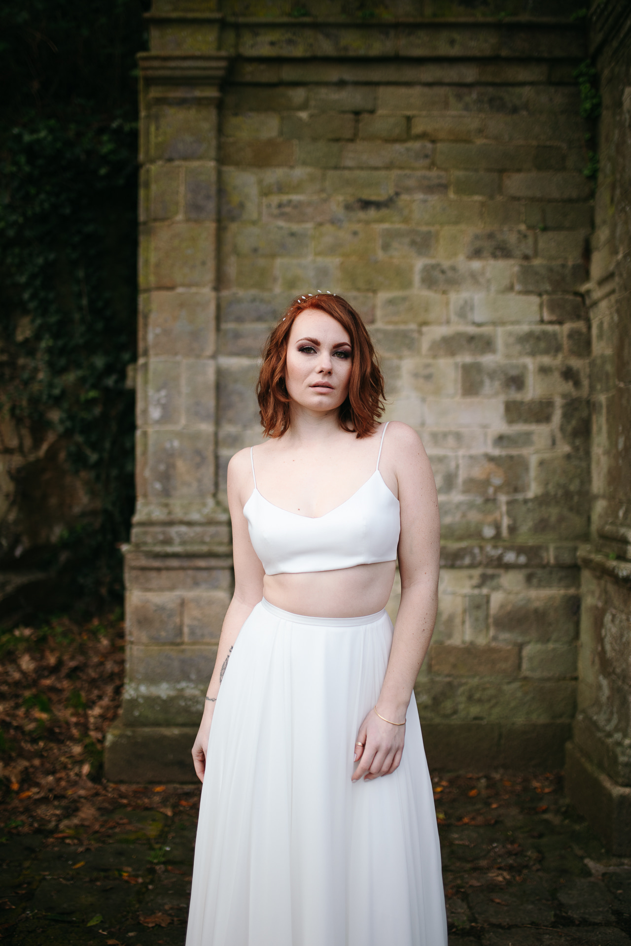 Femme portant une robe de mariée simple en Bretagne créée par Thom De Corbie.