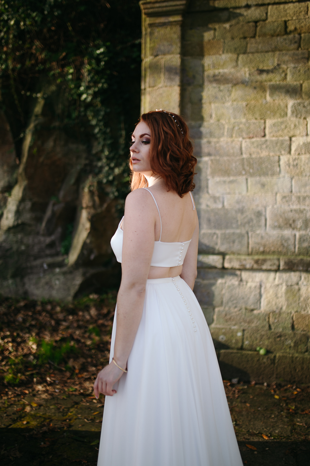 Femme portant une robe de mariée simple en Bretagne créée par Thom De Corbie.