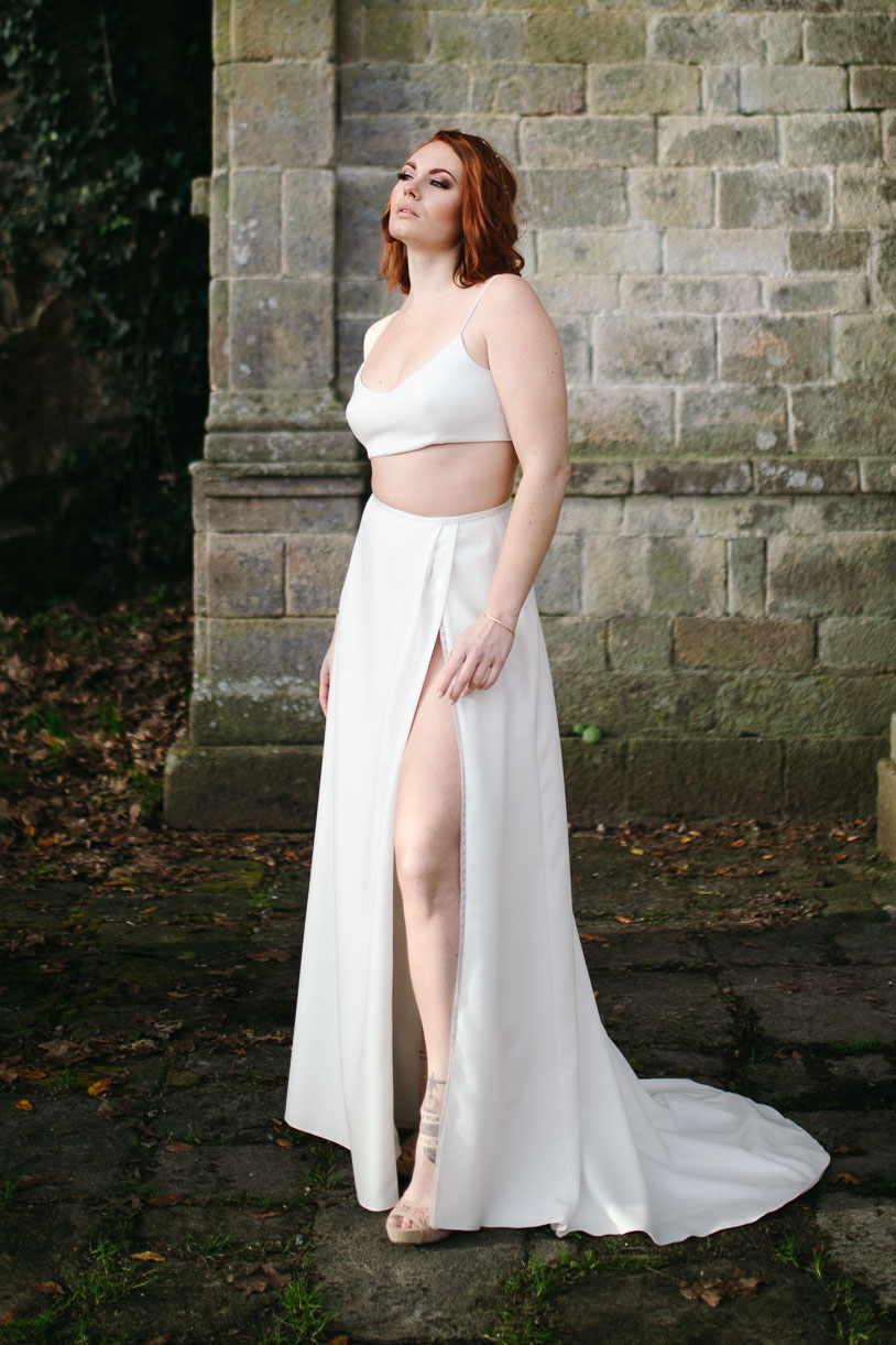 Femme portant une robe de mariée simple en Bretagne créée par Thom De Corbie.