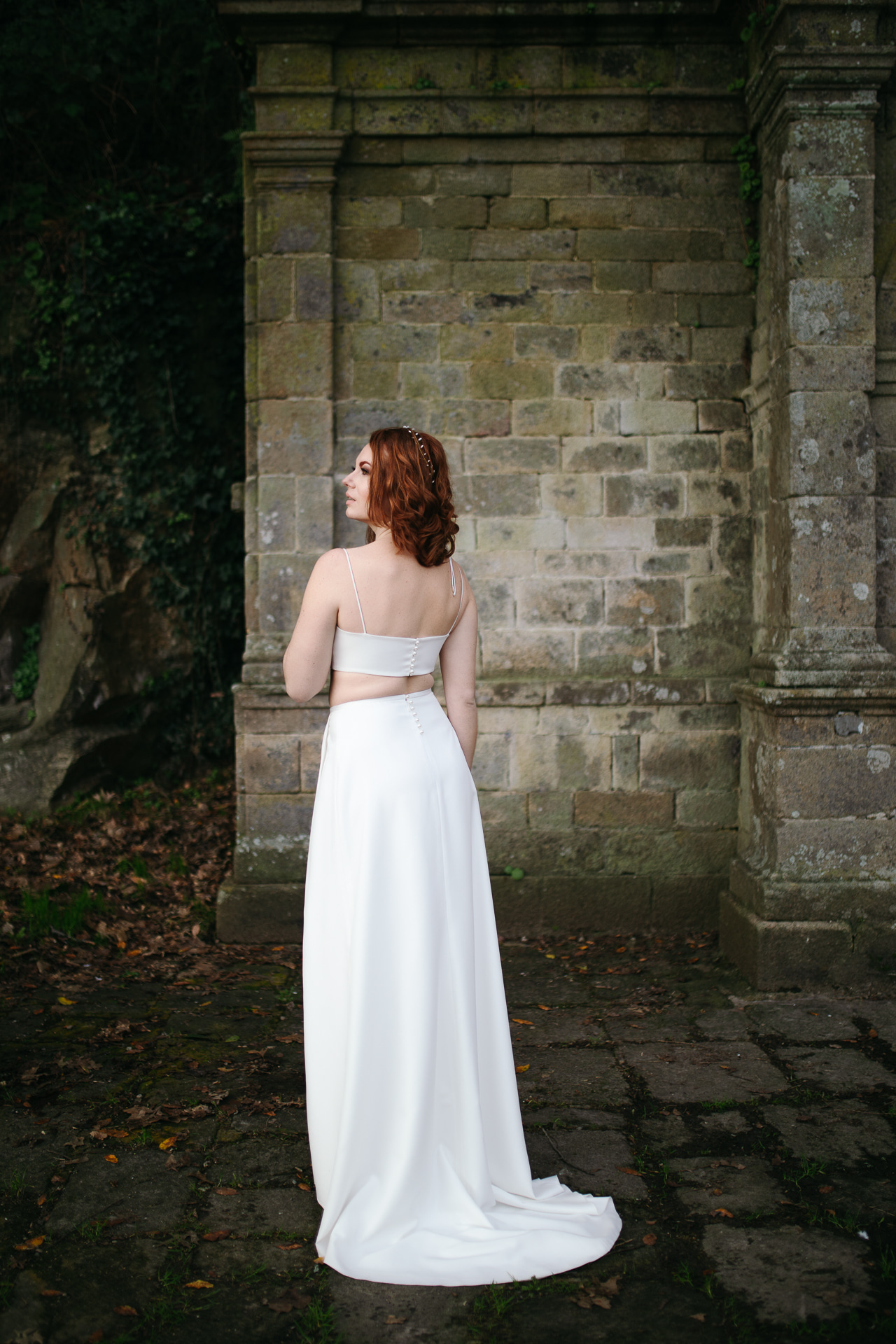 Femme portant une robe de mariée simple en Bretagne créée par Thom De Corbie.