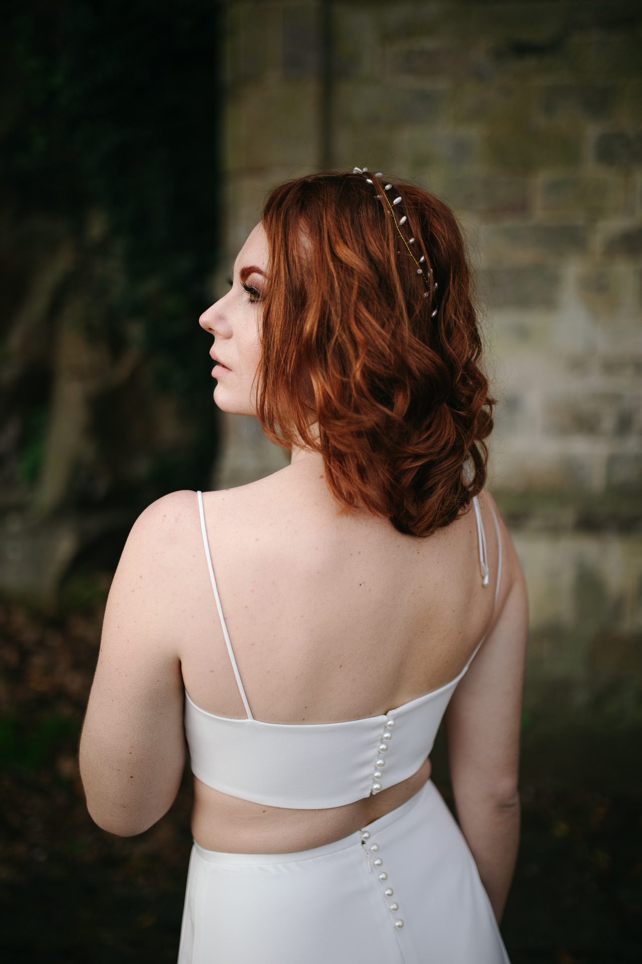 Femme portant une robe de mariée simple en Bretagne créée par Thom De Corbie.