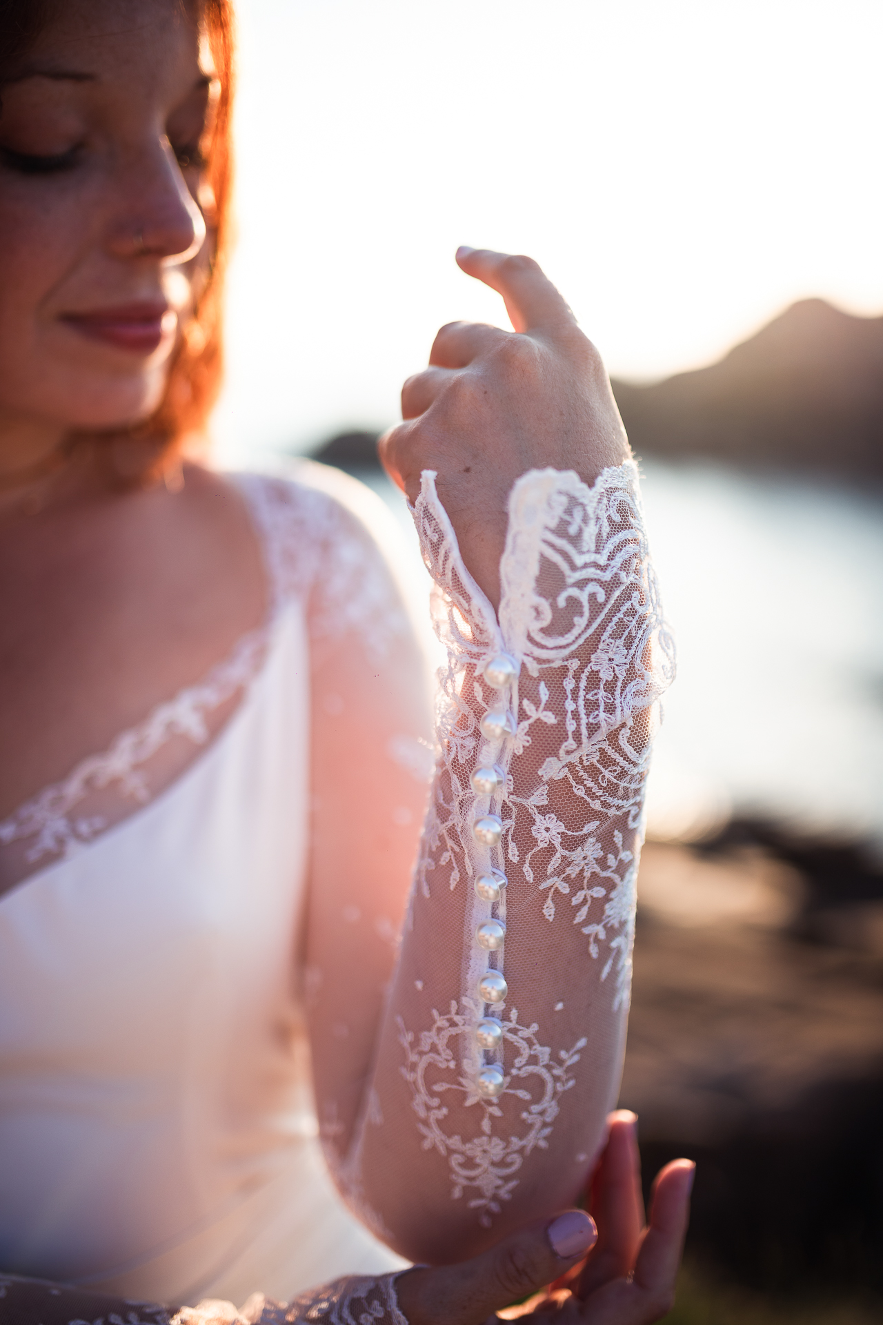 Femme portant une robe de mariée sirène en dentelle au bord de la mer en Bretagne.