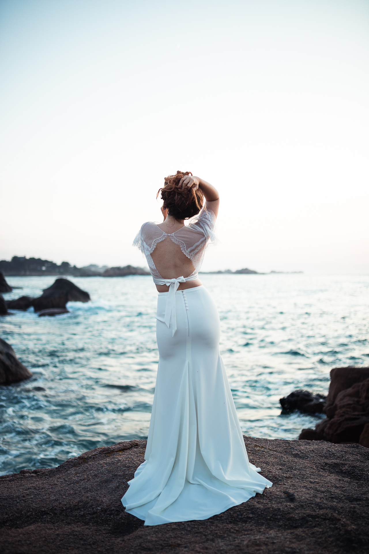 Femme portant une robe de mariée sirène au bord de la mer en Bretagne.