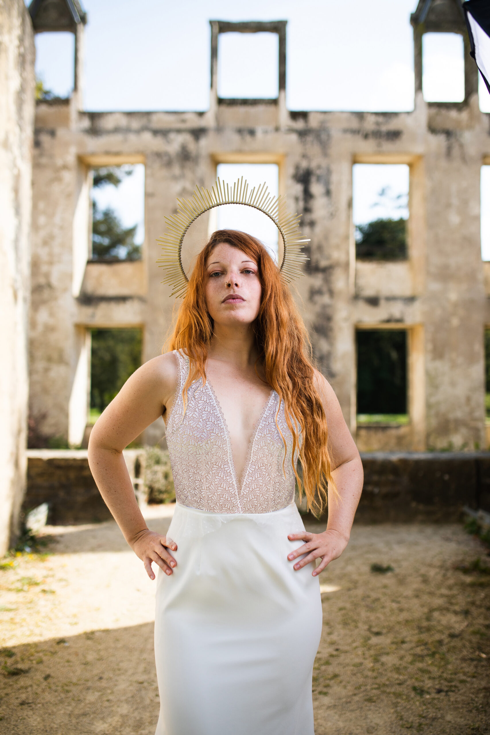 Femme portant une robe de mariée dans un château en ruine.