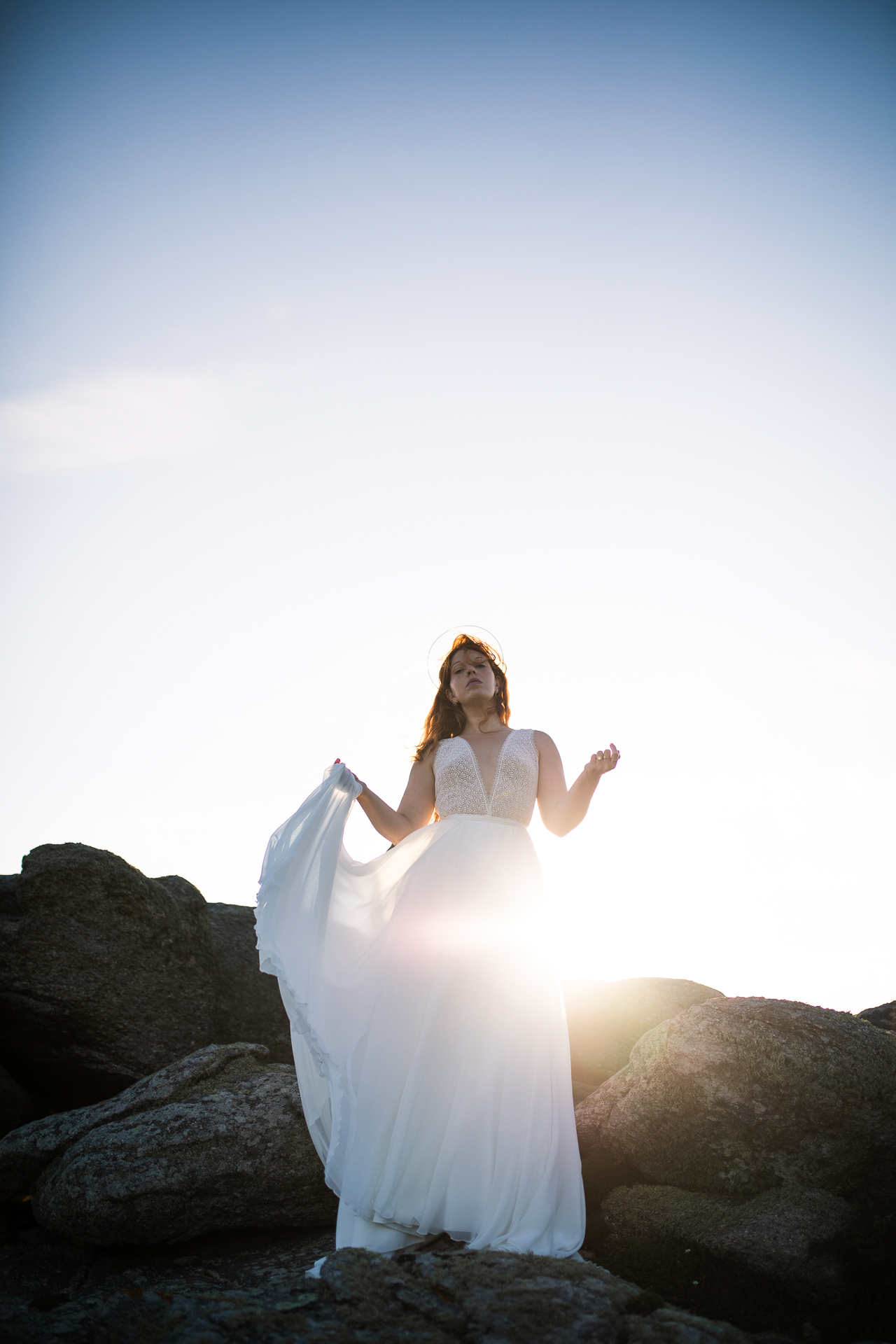 Femme portant une robe de mariée en dentelle au bord de la mer en Bretagne.