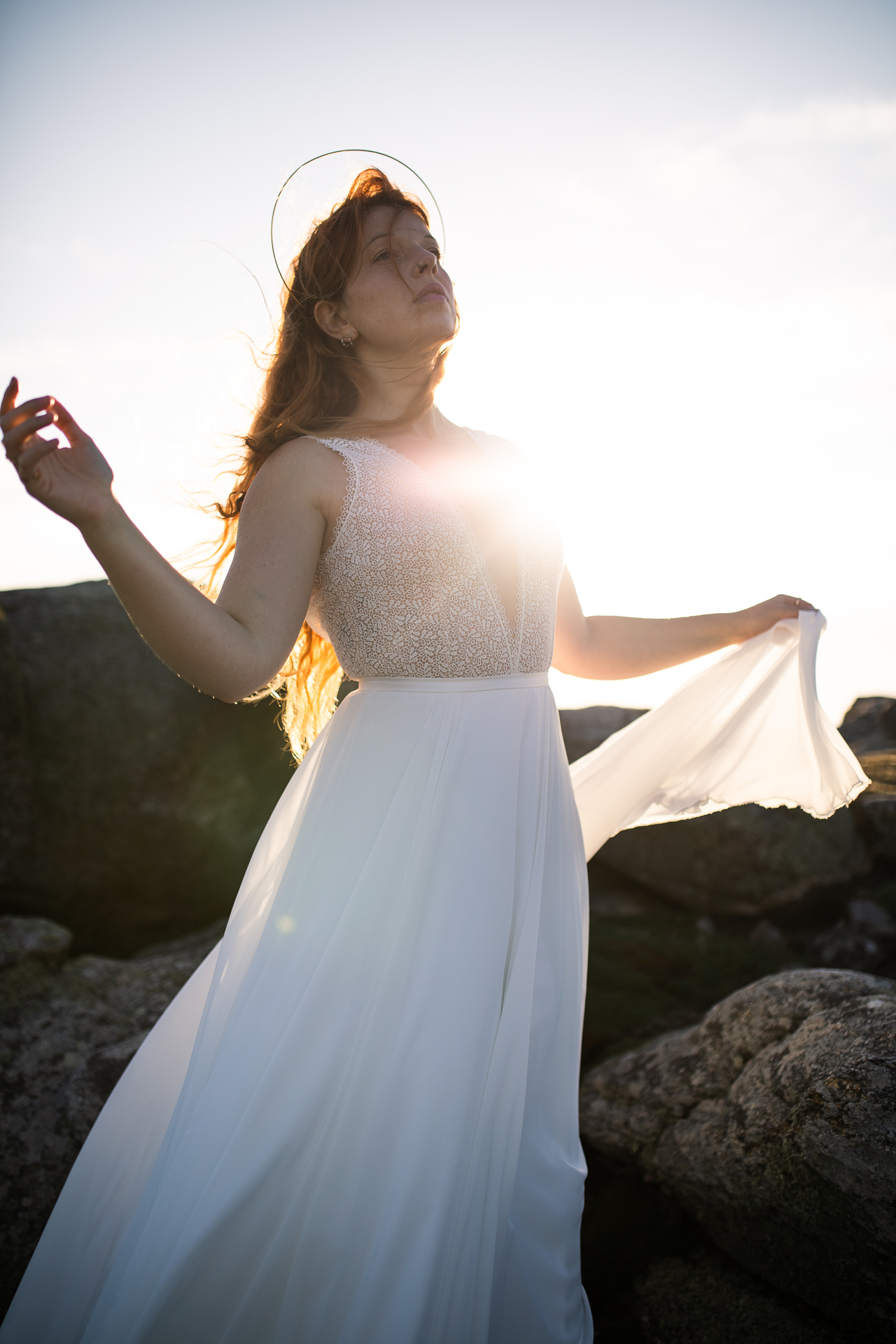 Femme portant une robe de mariée en dentelle au bord de la mer en Bretagne.