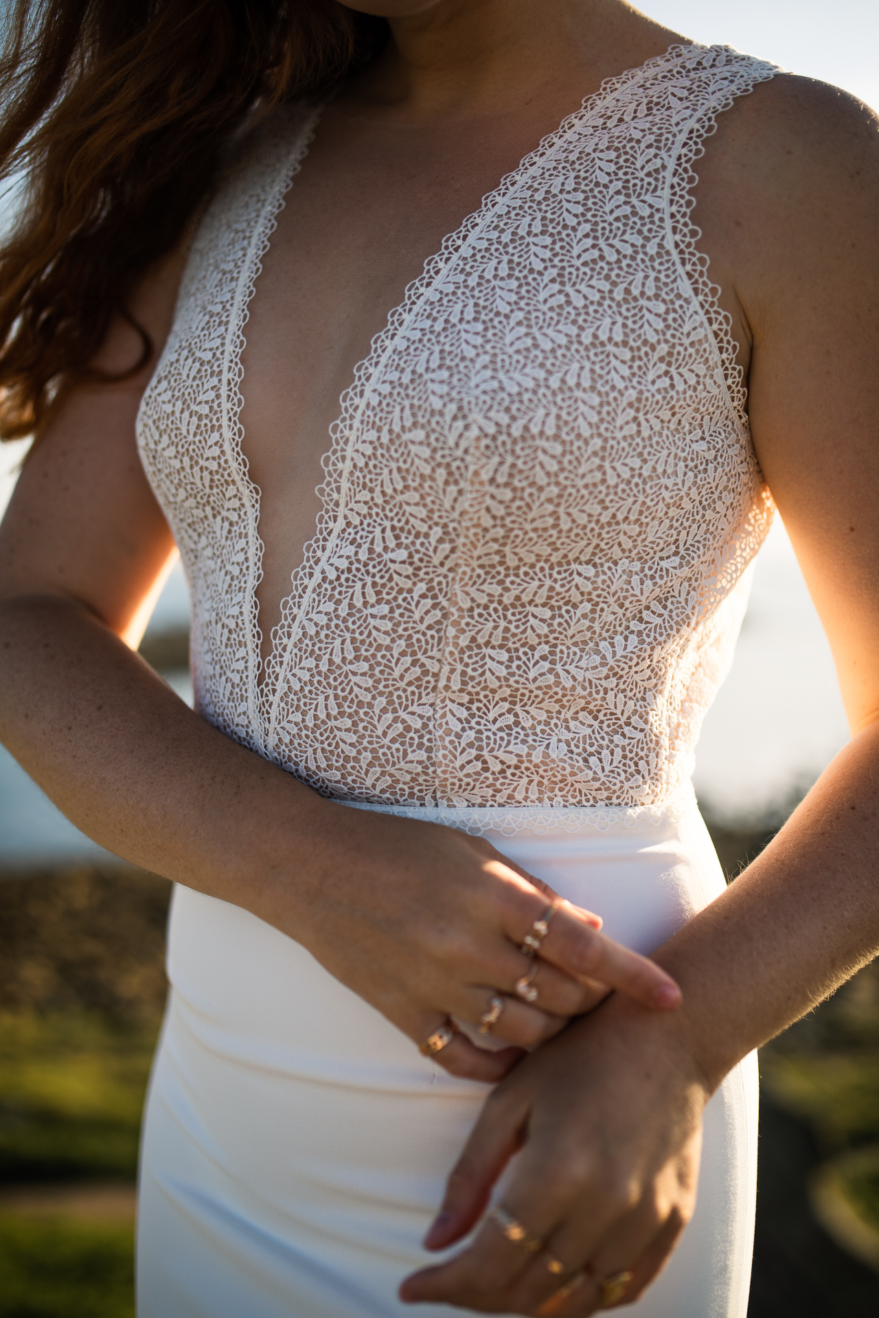 Femme portant une robe de mariée en dentelle au bord de la mer en Bretagne.