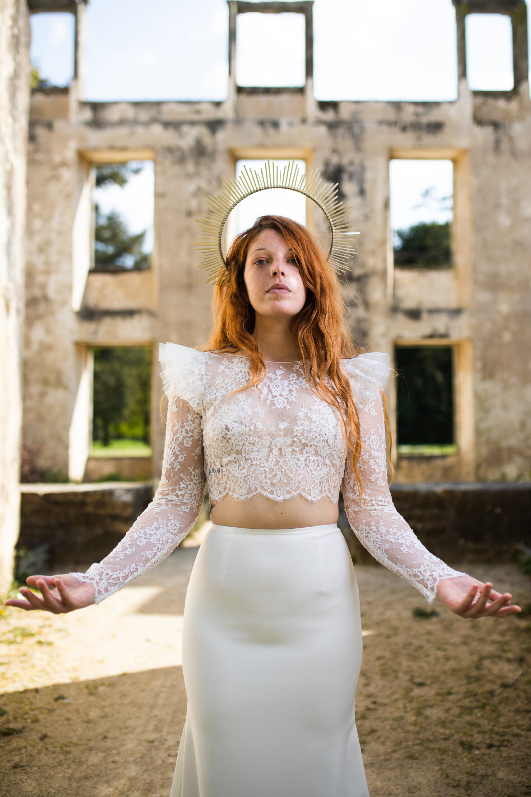 Femme portant une robe de mariée dans un château en ruine.