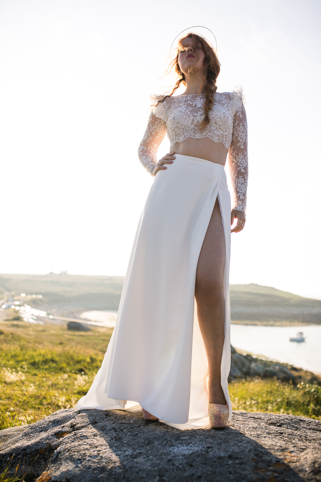 Femme portant une robe de mariée en dentelle au bord de la mer en Bretagne.