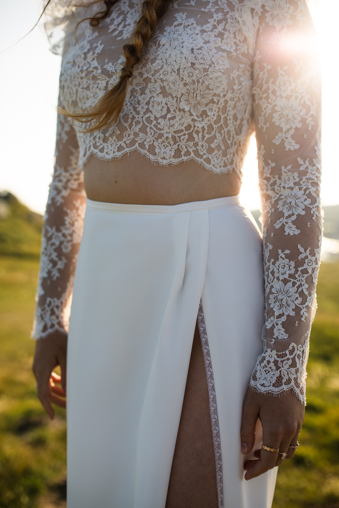 Femme portant une robe de mariée en dentelle au bord de la mer en Bretagne.