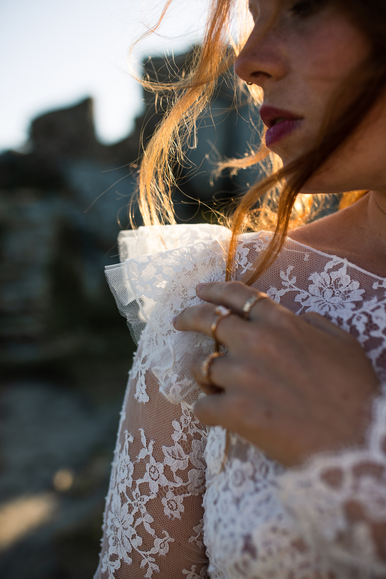 Femme portant une robe de mariée en dentelle au bord de la mer en Bretagne.