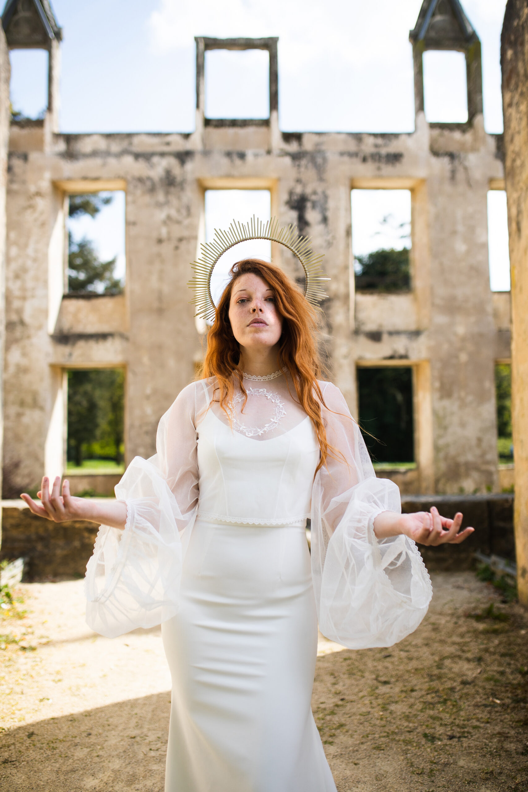 Femme portant une robe de mariée dans un château en ruine.
