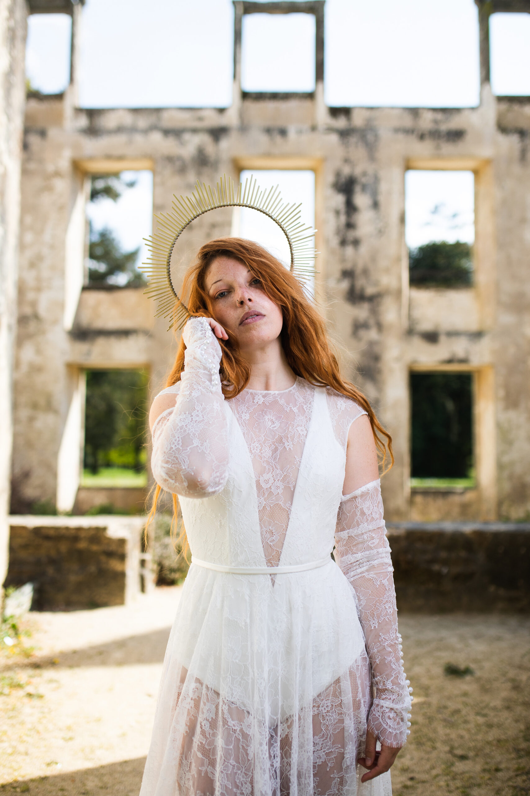 Femme portant une robe de mariée dans un château en ruine.