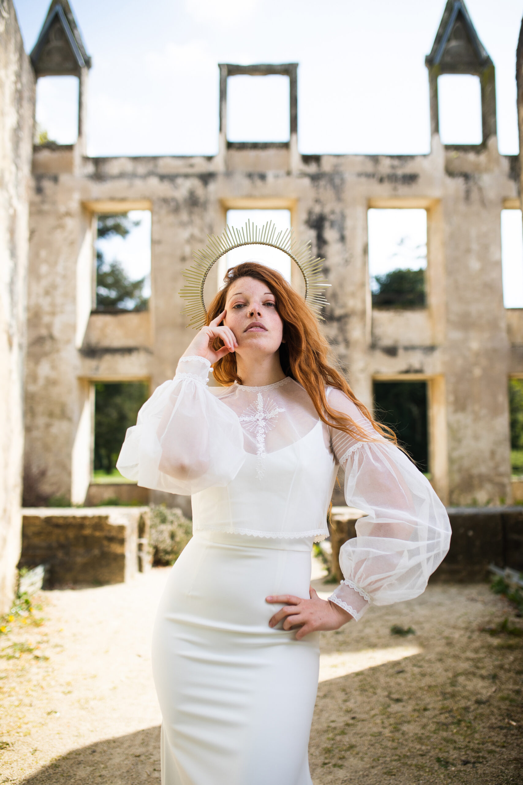 Femme portant une robe de mariée dans un château en ruine.
