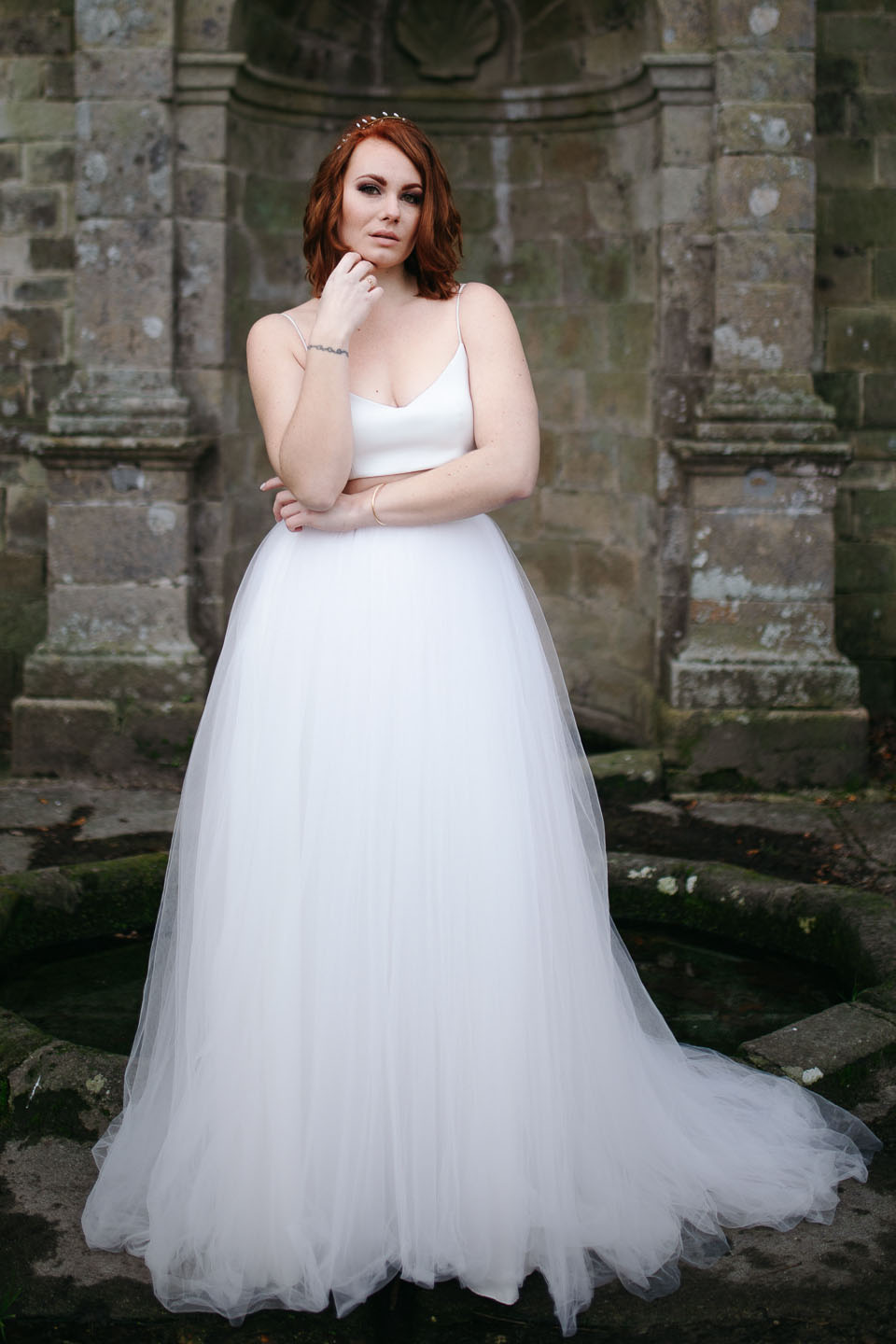 Femme portant une robe de mariée simple en Bretagne créée par Thom De Corbie.