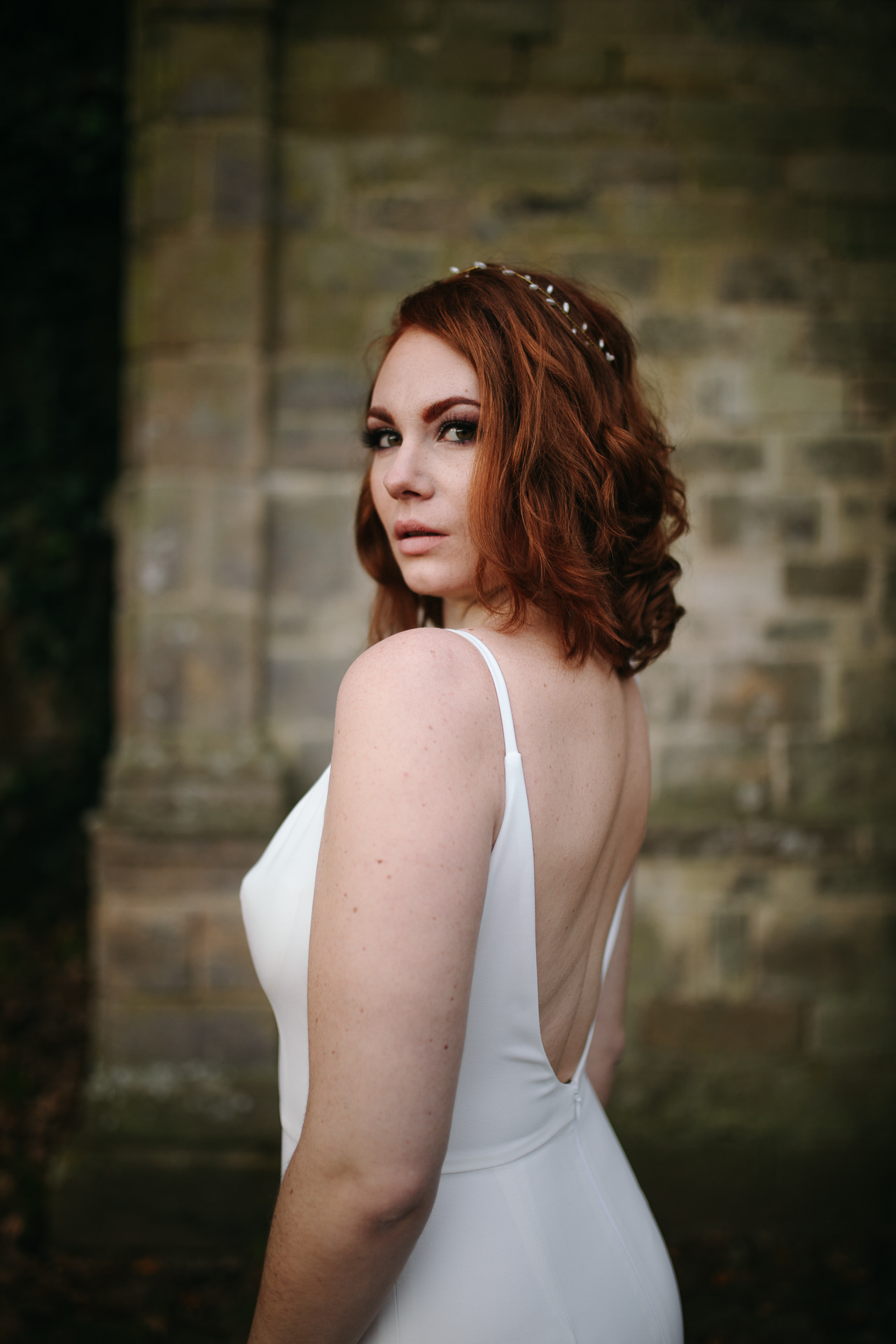 Femme portant une robe de mariée simple en Bretagne créée par Thom De Corbie.