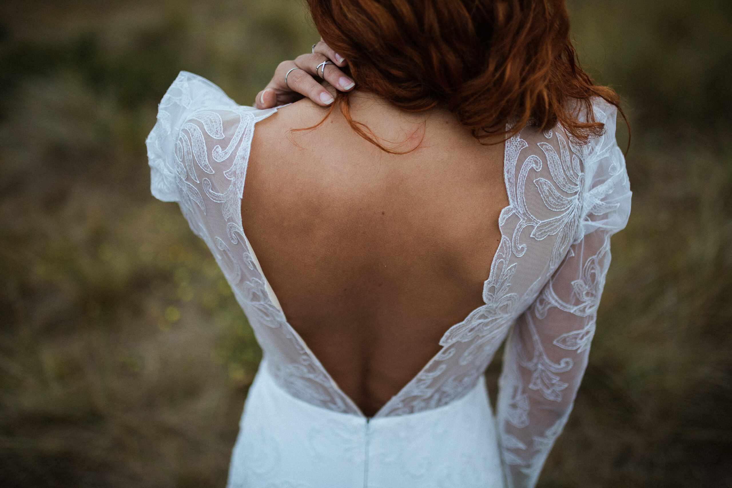 Femme de dos portant une robe de mariée dos nu.