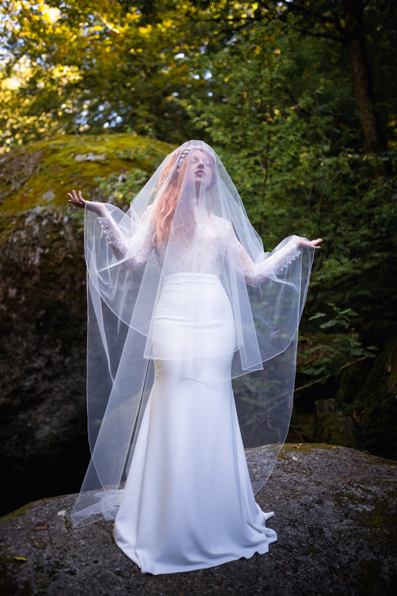 Femme portant une robe de mariée au milieu de la forêt.