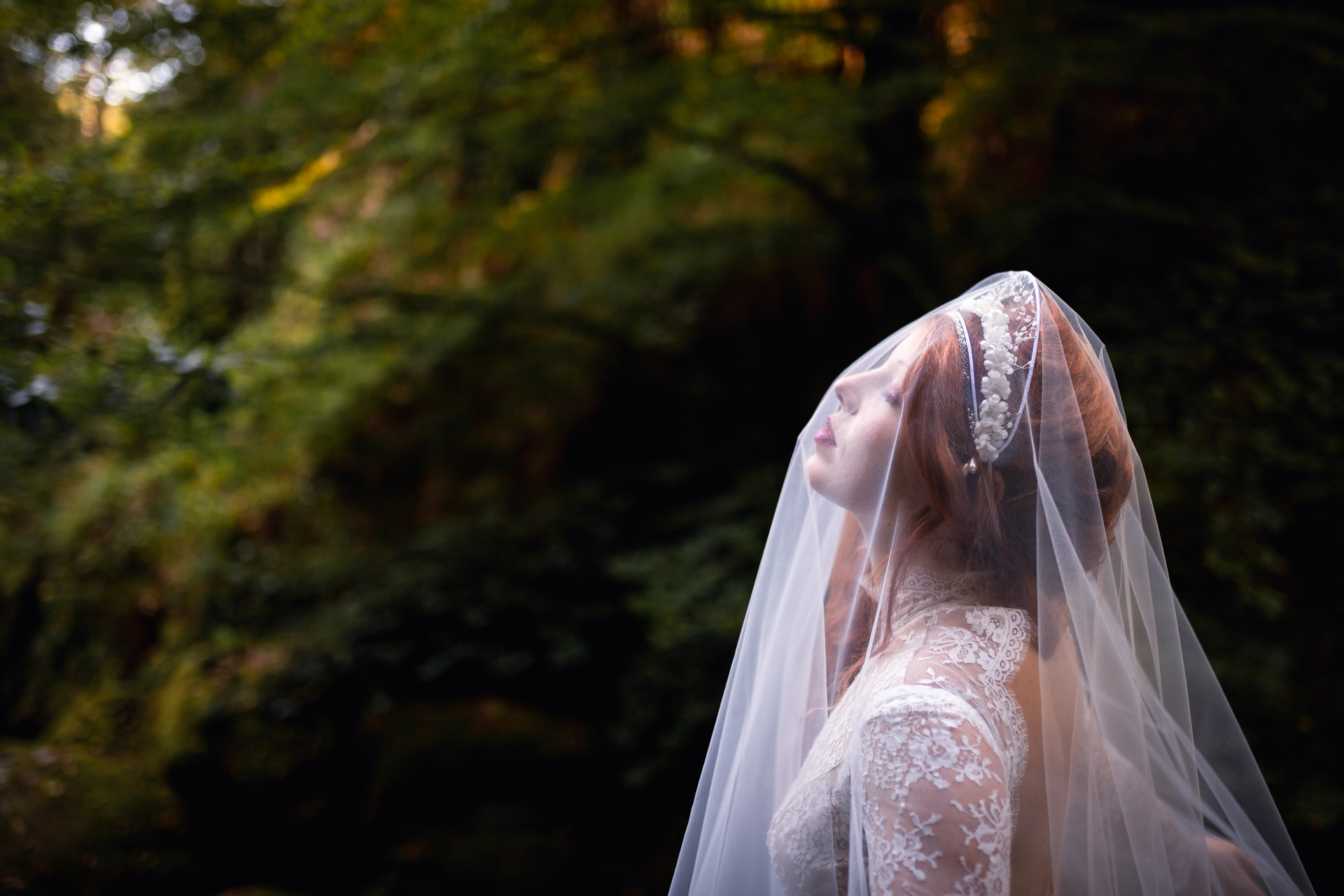 Femme portant une robe de mariée au milieu de la forêt.