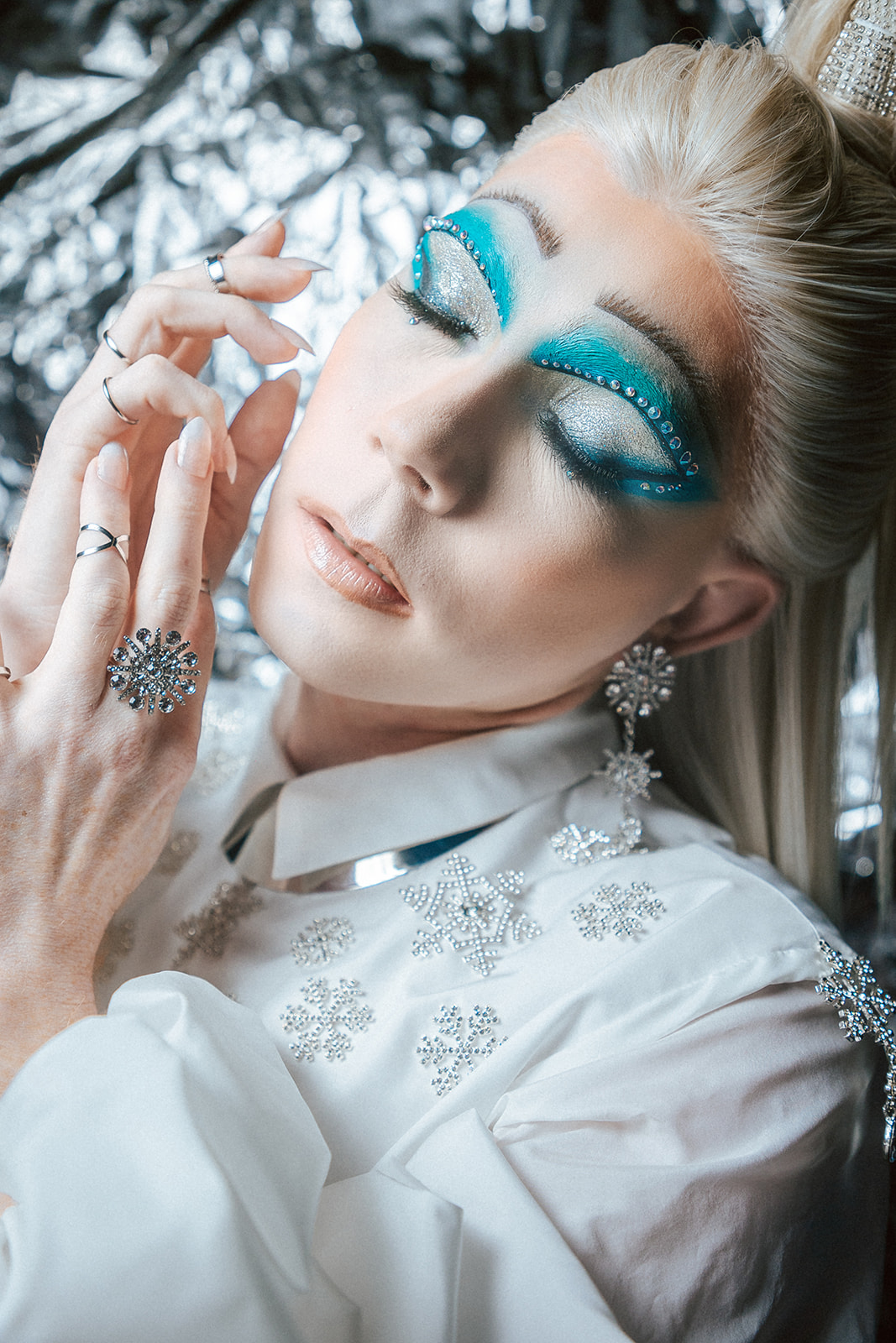 Drag queen portant une tenue de reine des glace blanche.