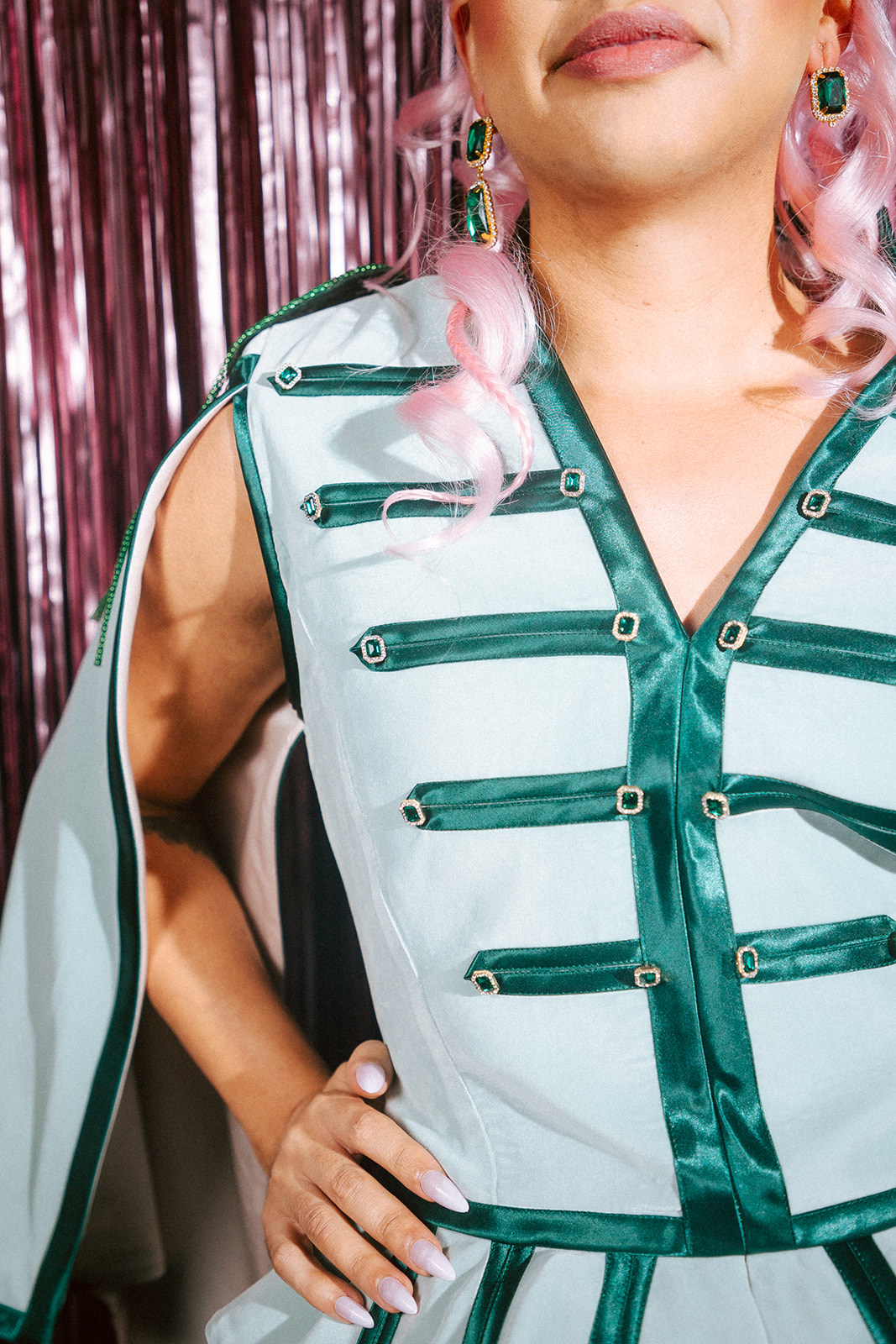 Drag queen portant une tenue casse-noisette verte et rose.