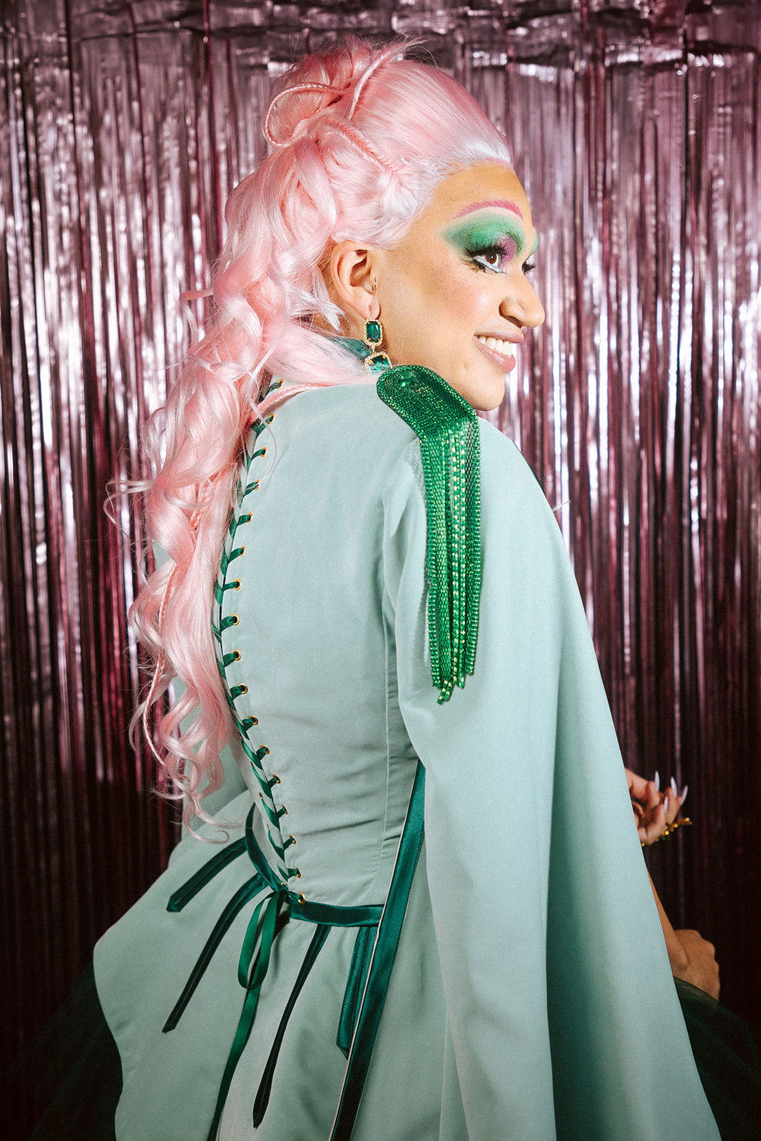 Drag queen portant une tenue casse-noisette verte et rose.