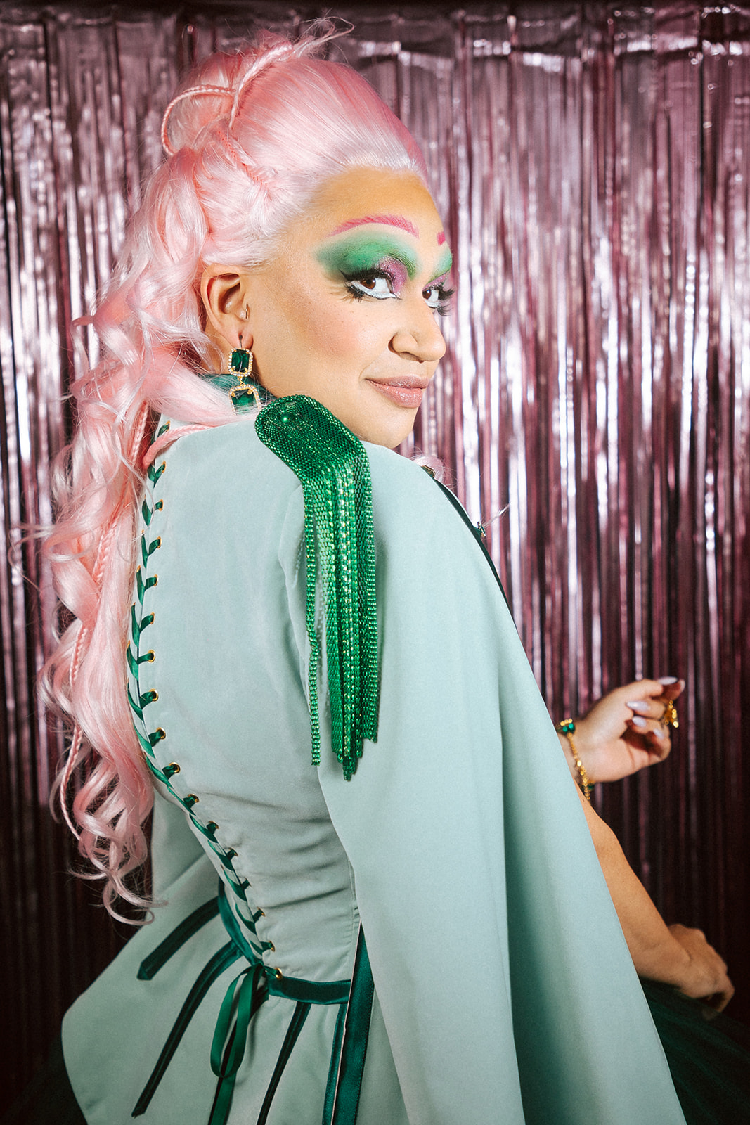 Drag queen portant une tenue casse-noisette verte et rose.