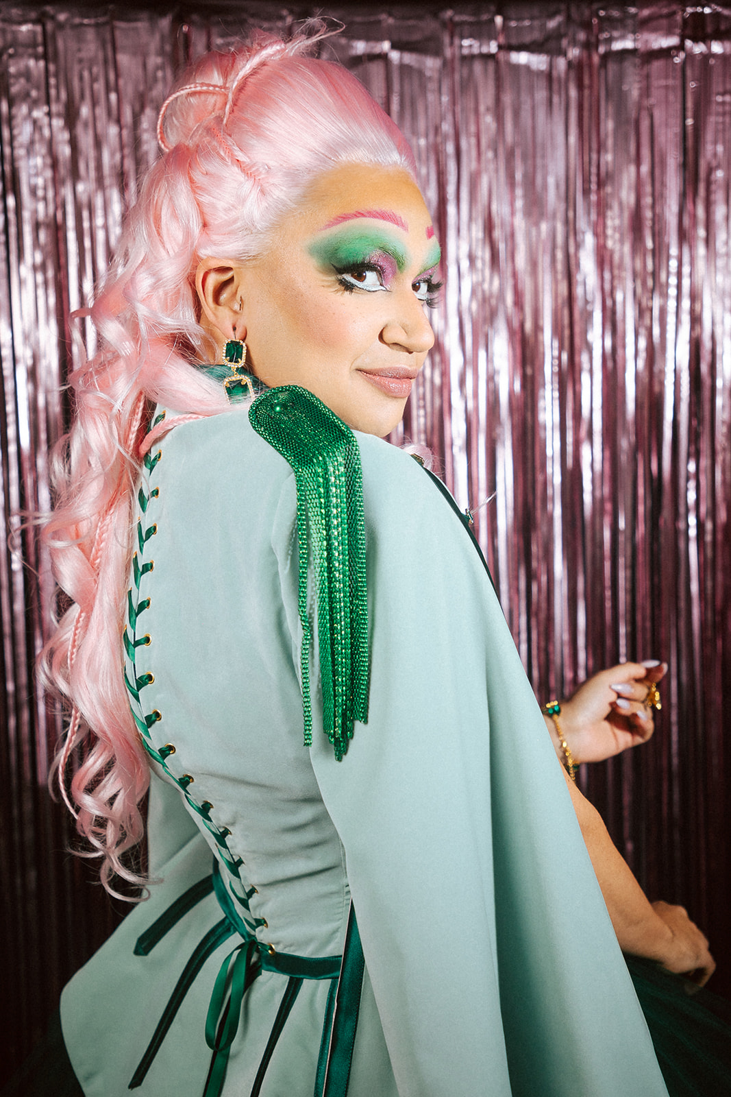 Drag queen portant une tenue casse-noisette verte et rose.