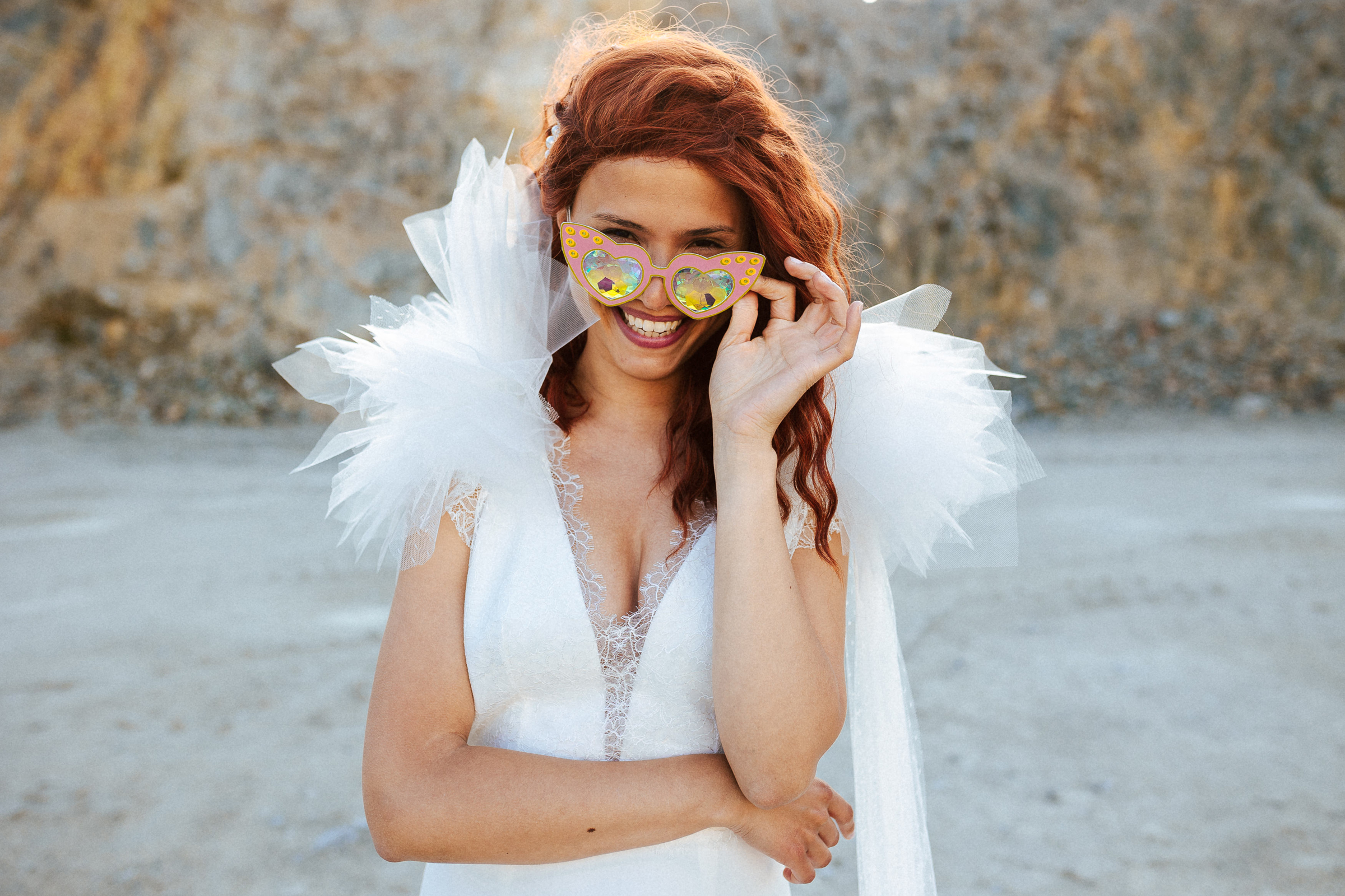 Femme rousse portant une robe de mariée de créateur en dentelle sur-mesure.