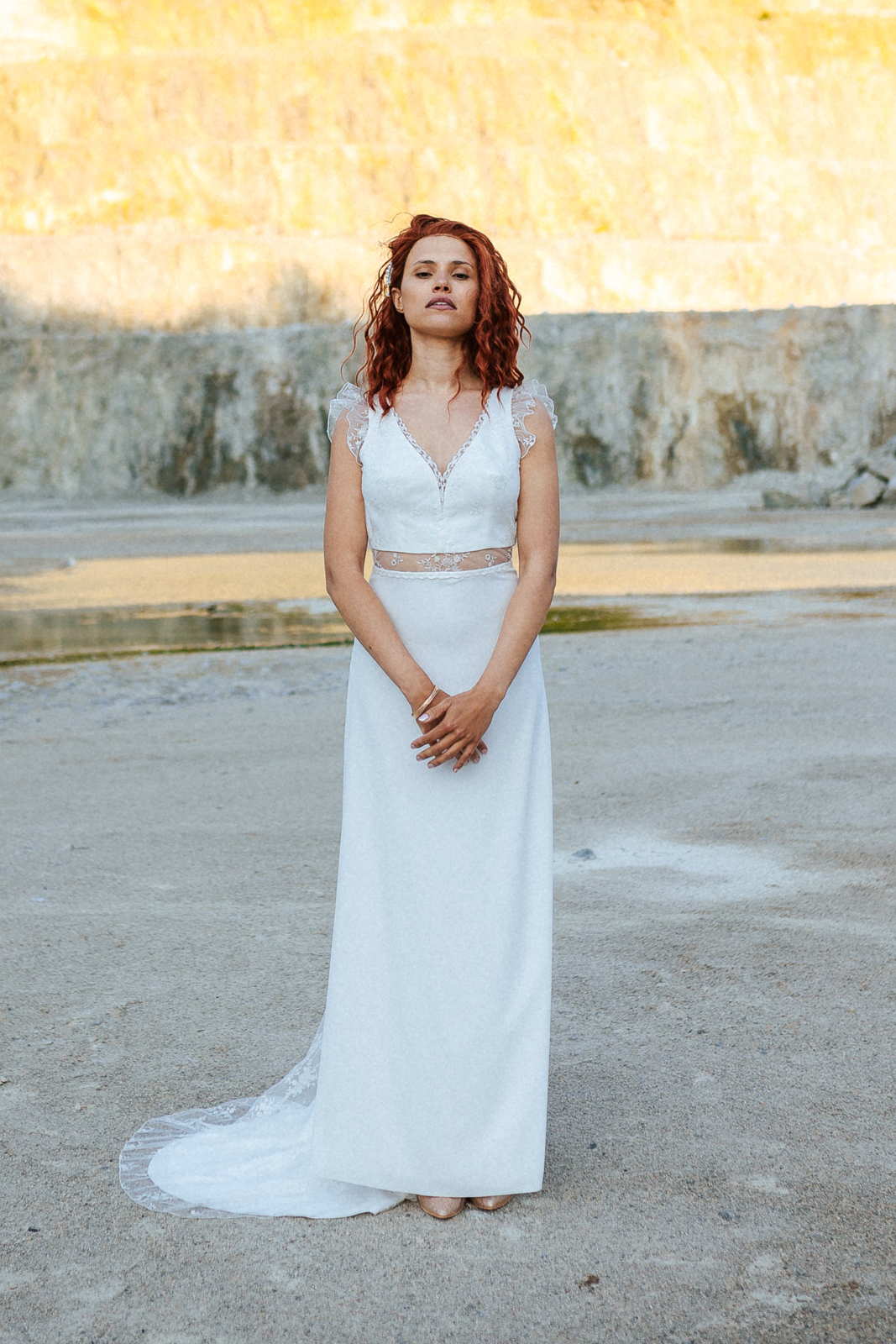 Femme rousse portant une robe de mariée bohème de créateur en dentelle sur-mesure.