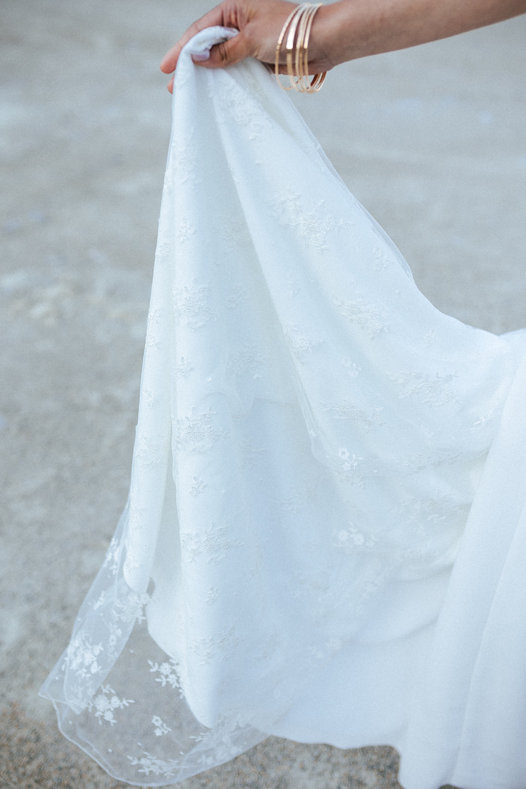 Femme rousse portant une robe de mariée bohème de créateur en dentelle sur-mesure.