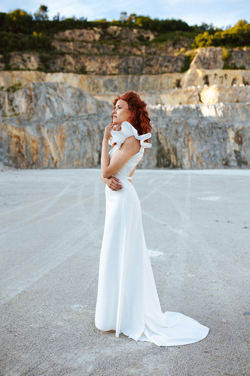 Femme rousse portant une robe de mariée bohème de créateur en dentelle sur-mesure.