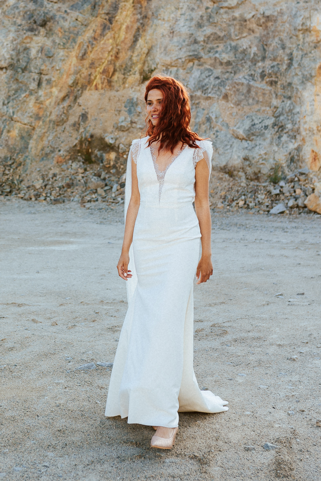 Femme rousse portant une robe de mariée originale de créateur en dentelle sur-mesure.