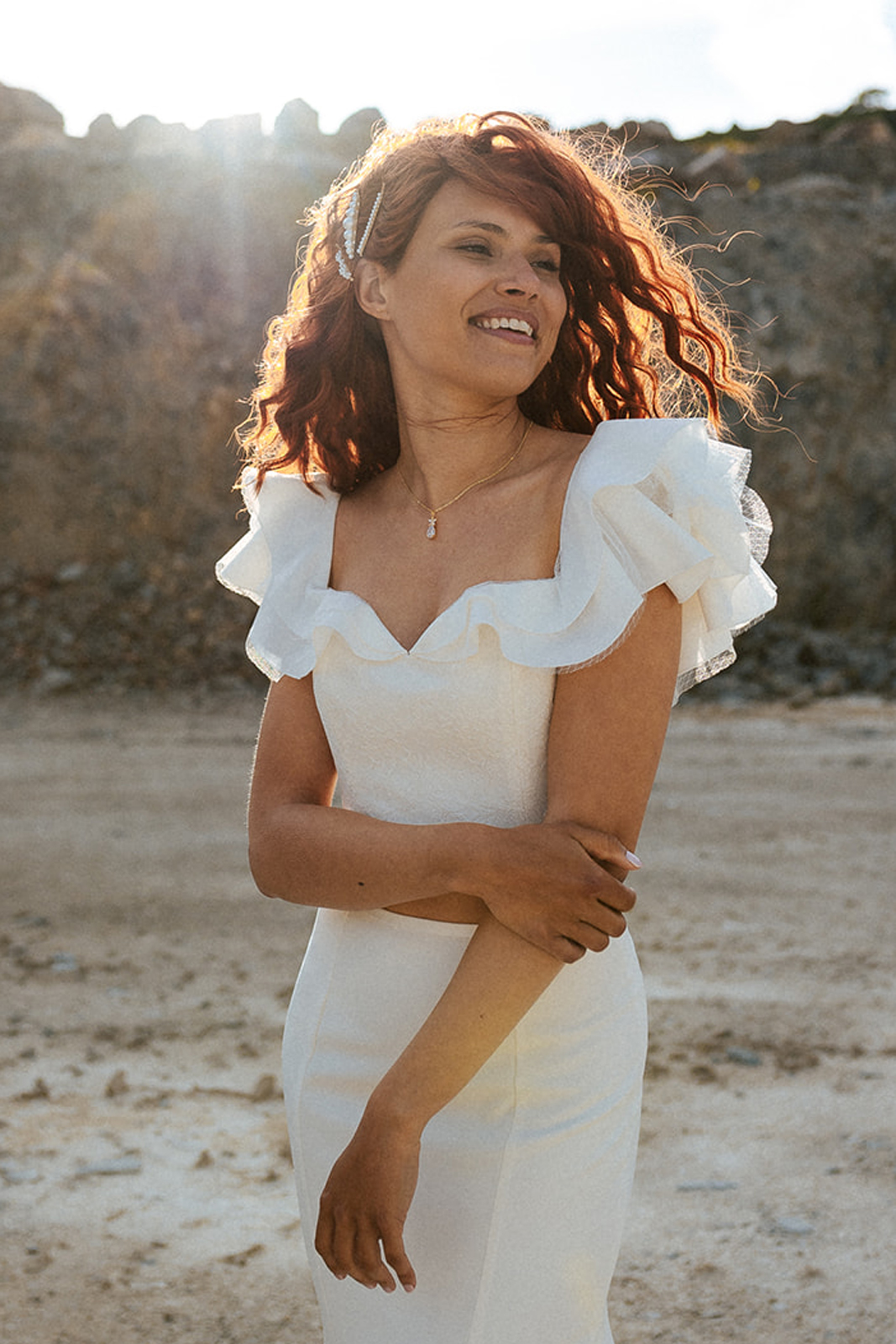 Femme rousse portant une robe de mariée bustier de créateur en dentelle sur-mesure.