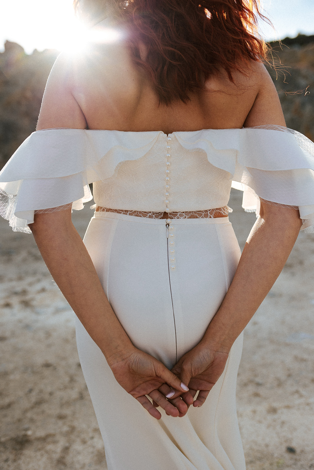 Femme rousse portant une robe de mariée bustier de créateur en dentelle sur-mesure.
