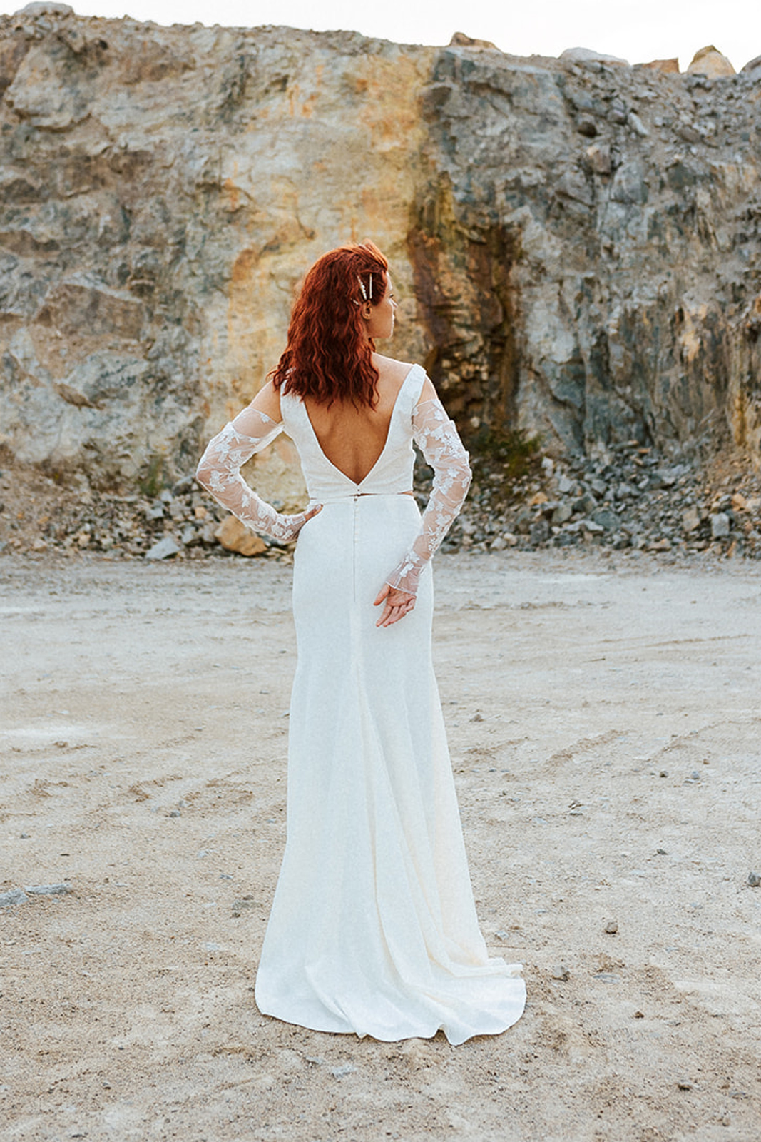 Femme rousse portant une robe de mariée de créateur en dentelle sur-mesure.