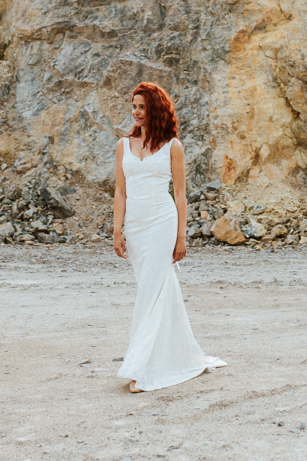 Femme rousse portant une robe de mariée de créateur en dentelle sur-mesure.