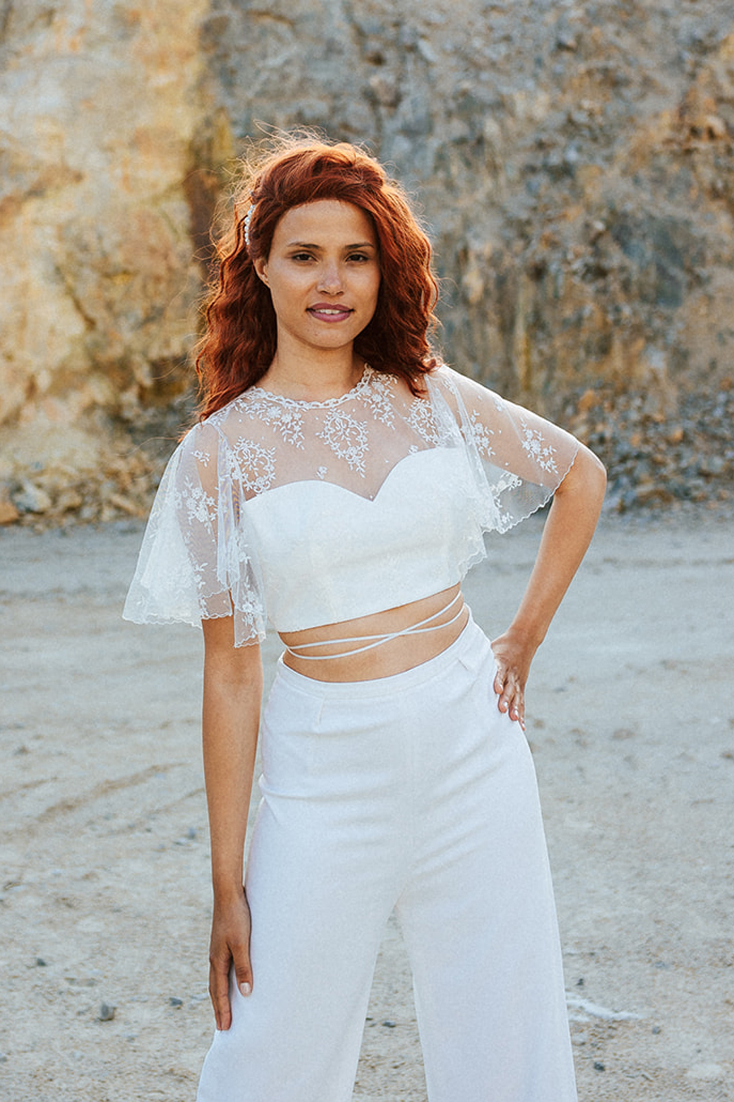 Femme rousse portant une robe de mariée de créateur en dentelle sur-mesure.