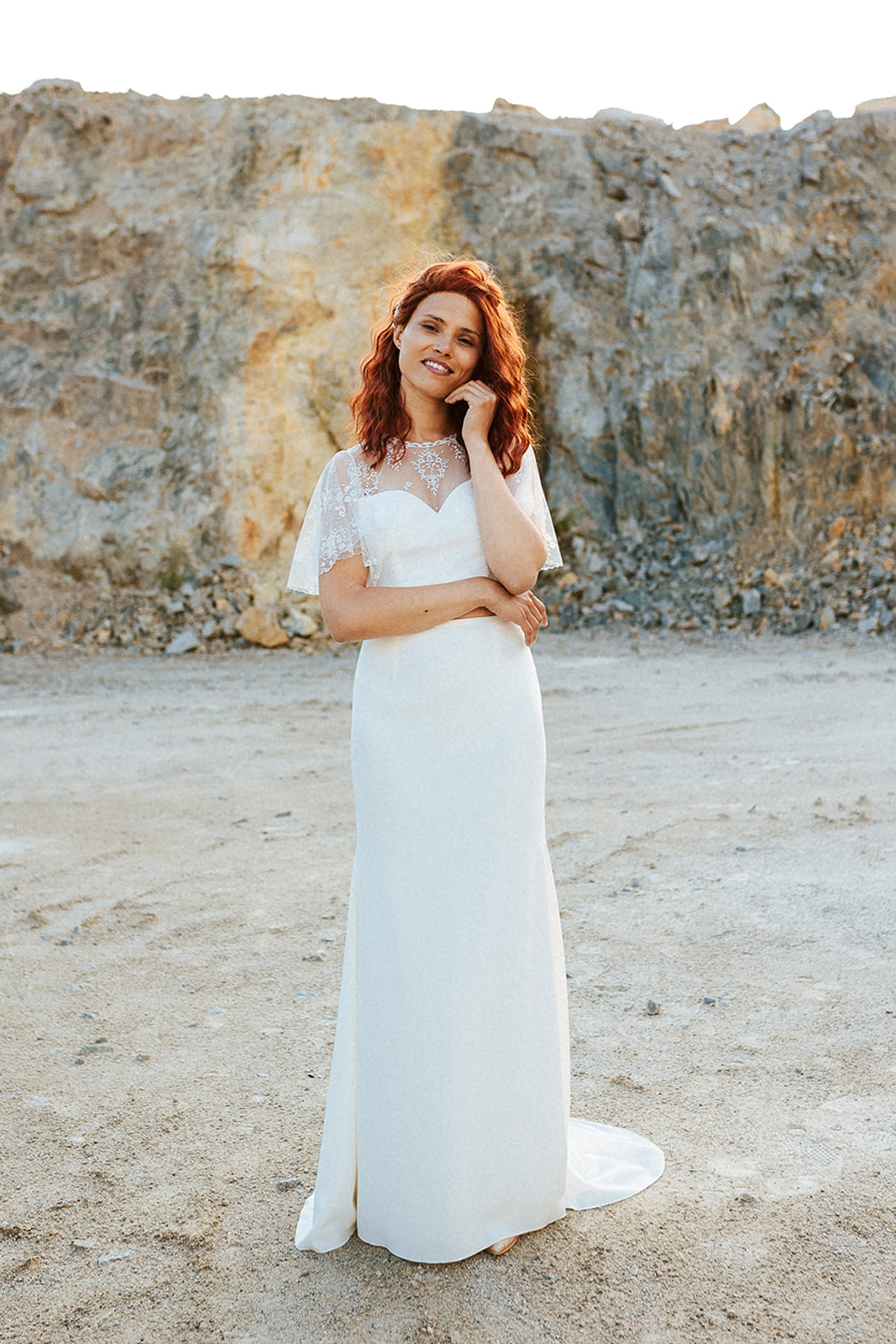 Femme rousse portant une robe de mariée de créateur en dentelle sur-mesure.