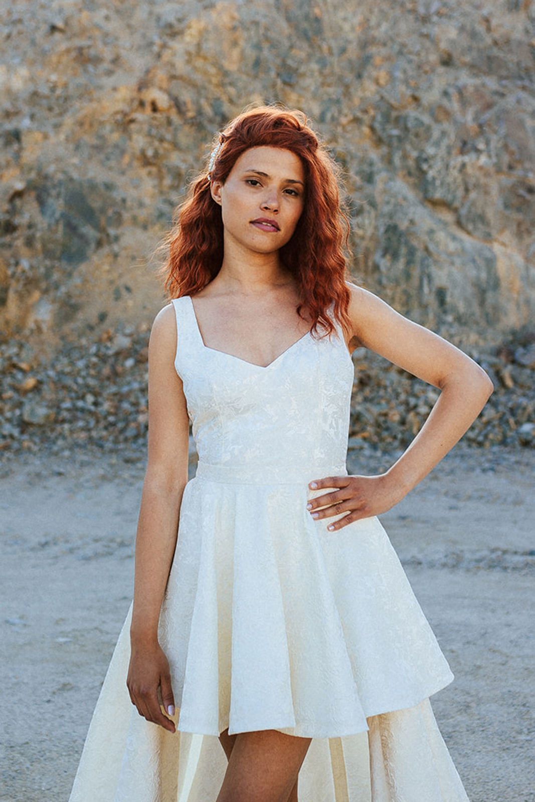 Femme rousse portant une robe de mariée de créateur asymétrique sur-mesure.
