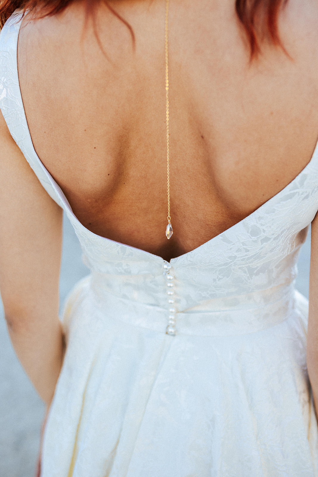 Femme rousse portant une robe de mariée de créateur asymétrique sur-mesure.
