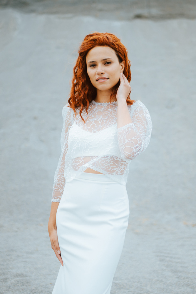 Femme rousse portant une robe de mariée de créateur sirène en dentelle sur-mesure en Bretagne.