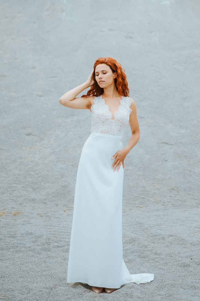 Femme rousse portant une robe de mariée bohème de créateur en dentelle sur-mesure en Bretagne.